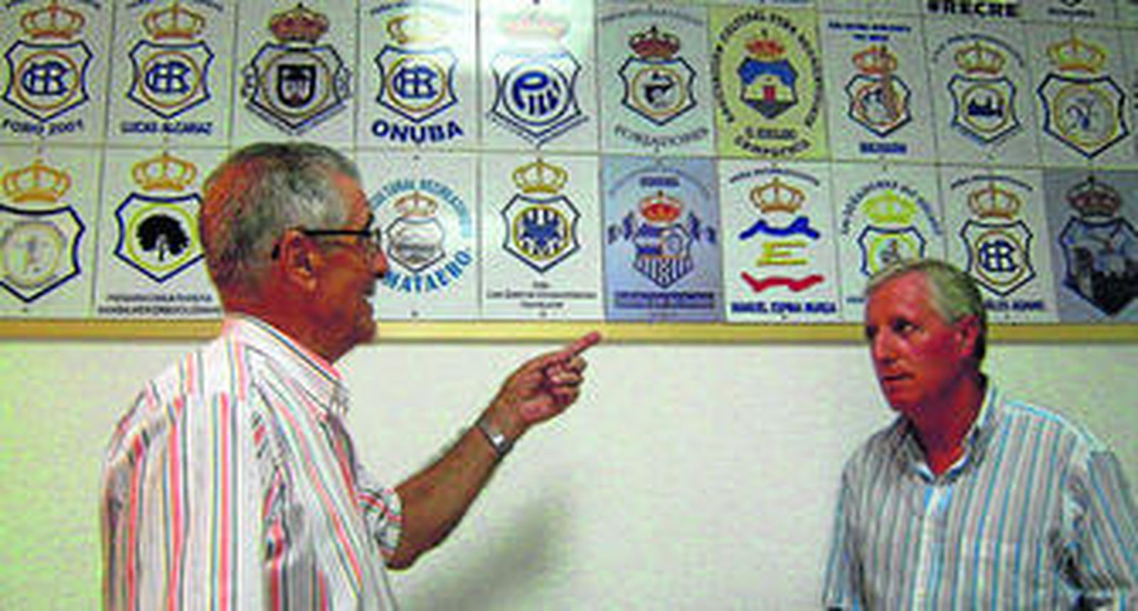 Juan Córdoba y Eduardo Negri ante el mosaico con los escudos de todas las peñas.