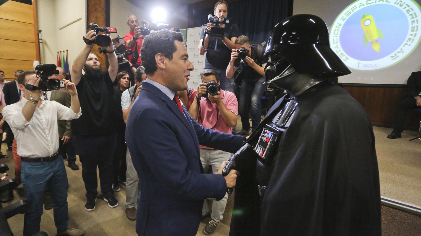 El presidente de la Junta saluda a un voluntario caracterizado de Darth Vader.