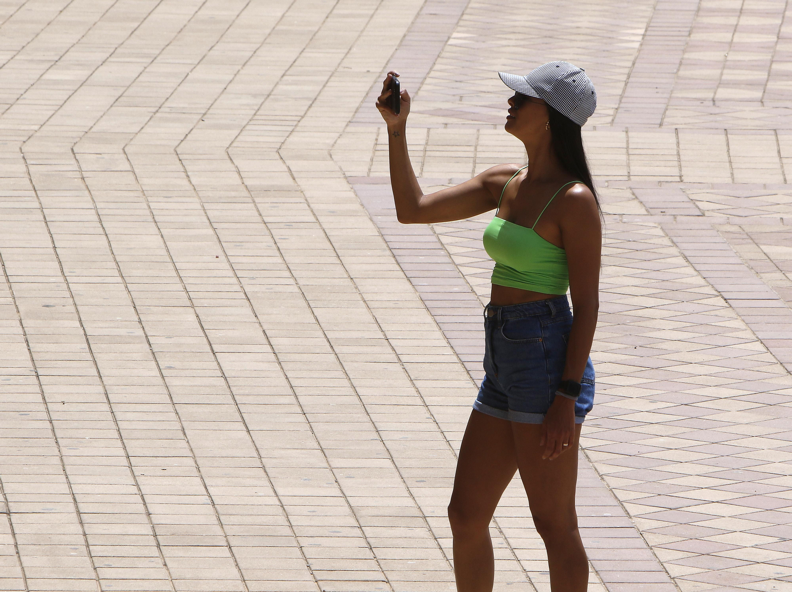 Una joven haciendo una foto a pleno sol.
