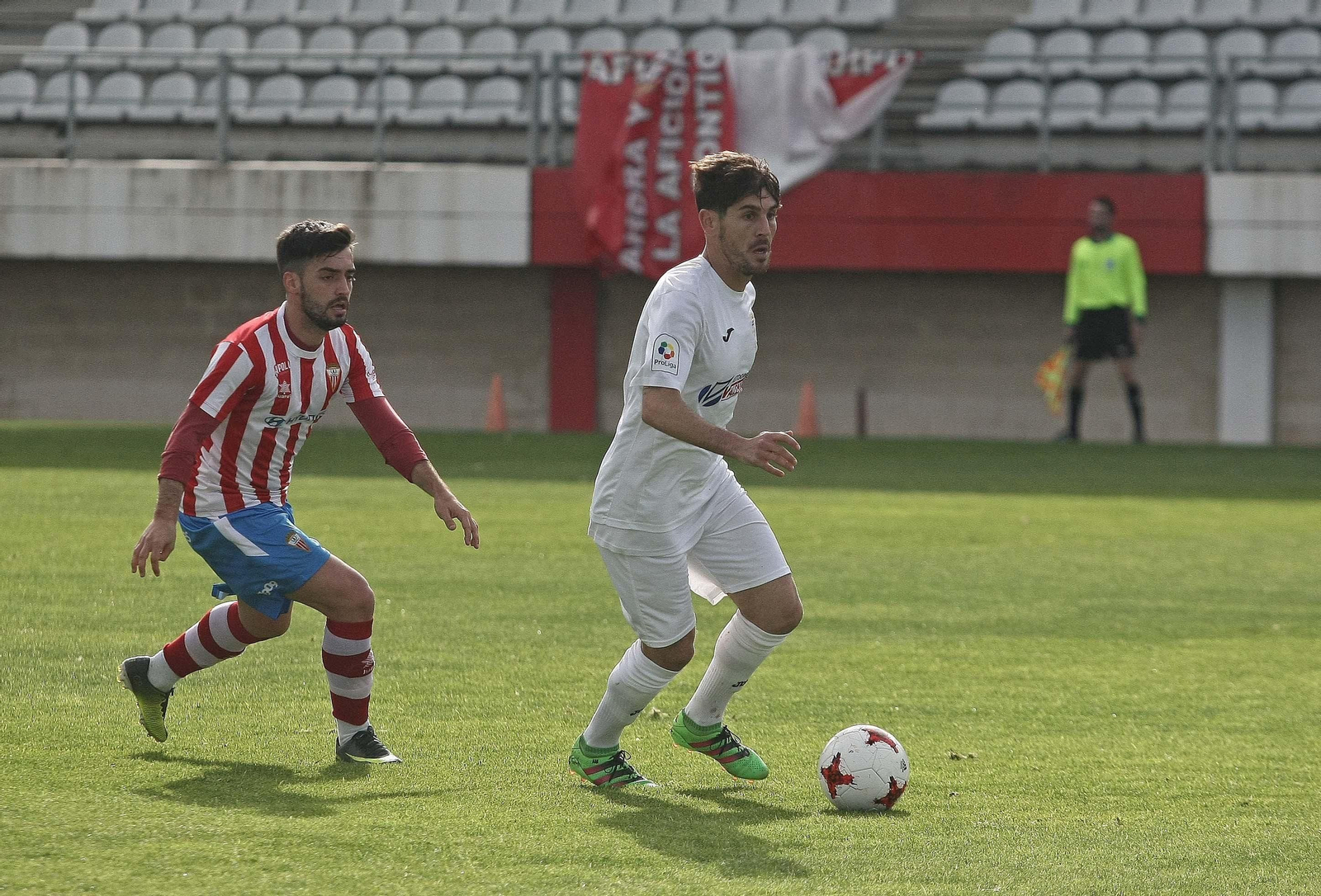 Manzano conduce el balón en el duelo que disputó el Arcos en el Nuevo Mirador seguido por Tano.