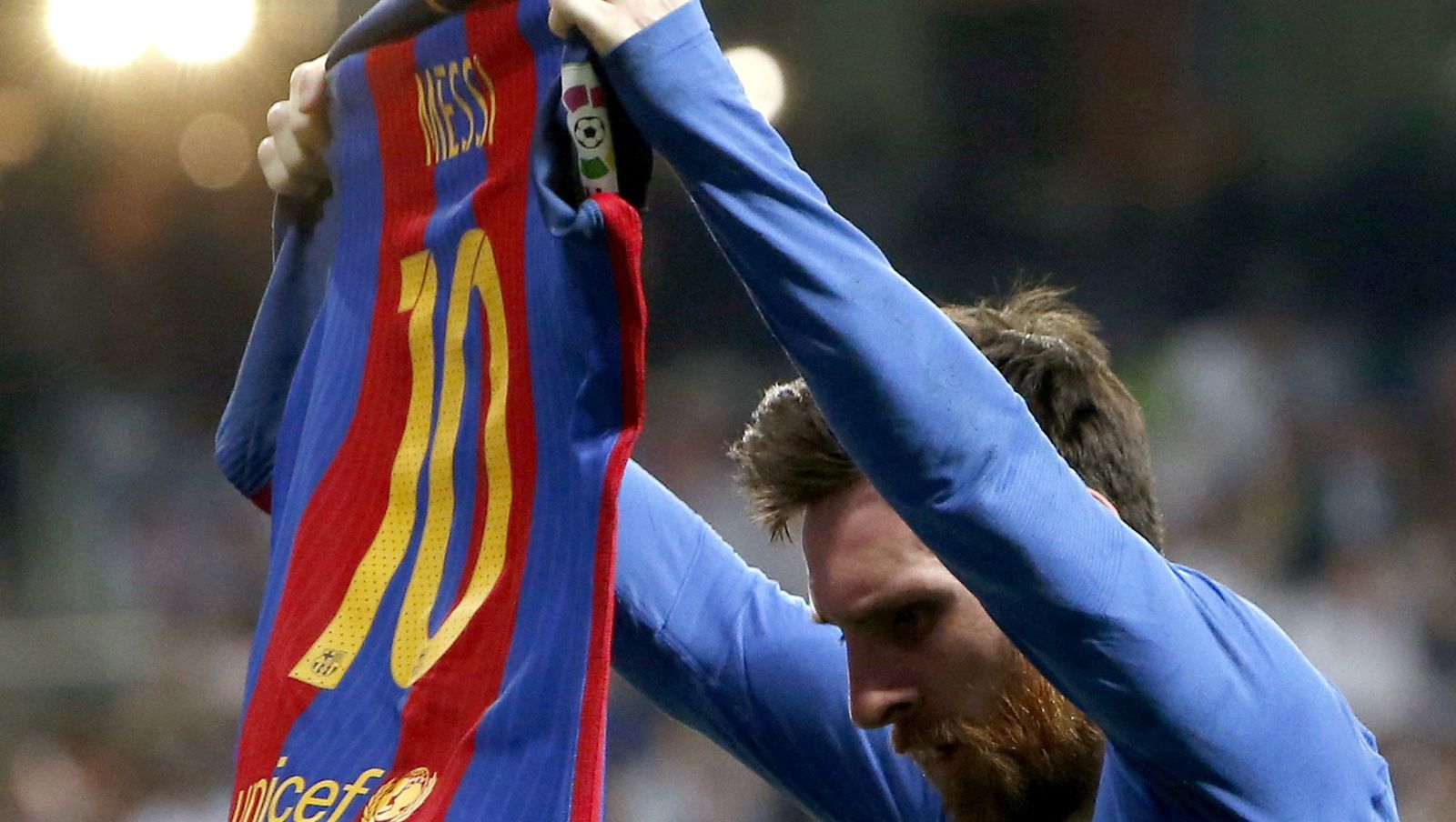 Messi enseña su camiseta al Bernabéu.