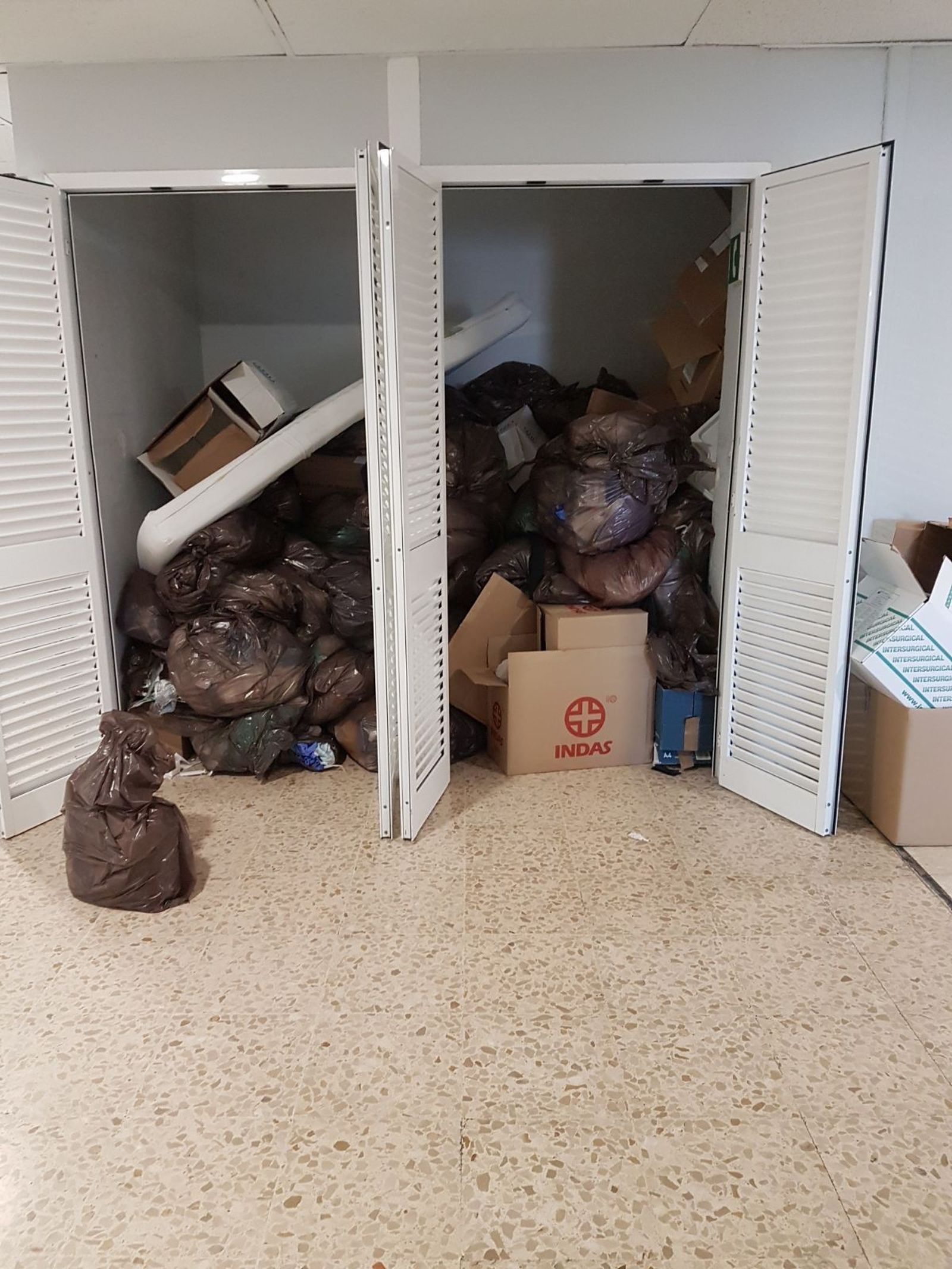 Bolsas de basura acumuladas en un armario del hospital por falta de personal para recogerlas el pasado viernes.