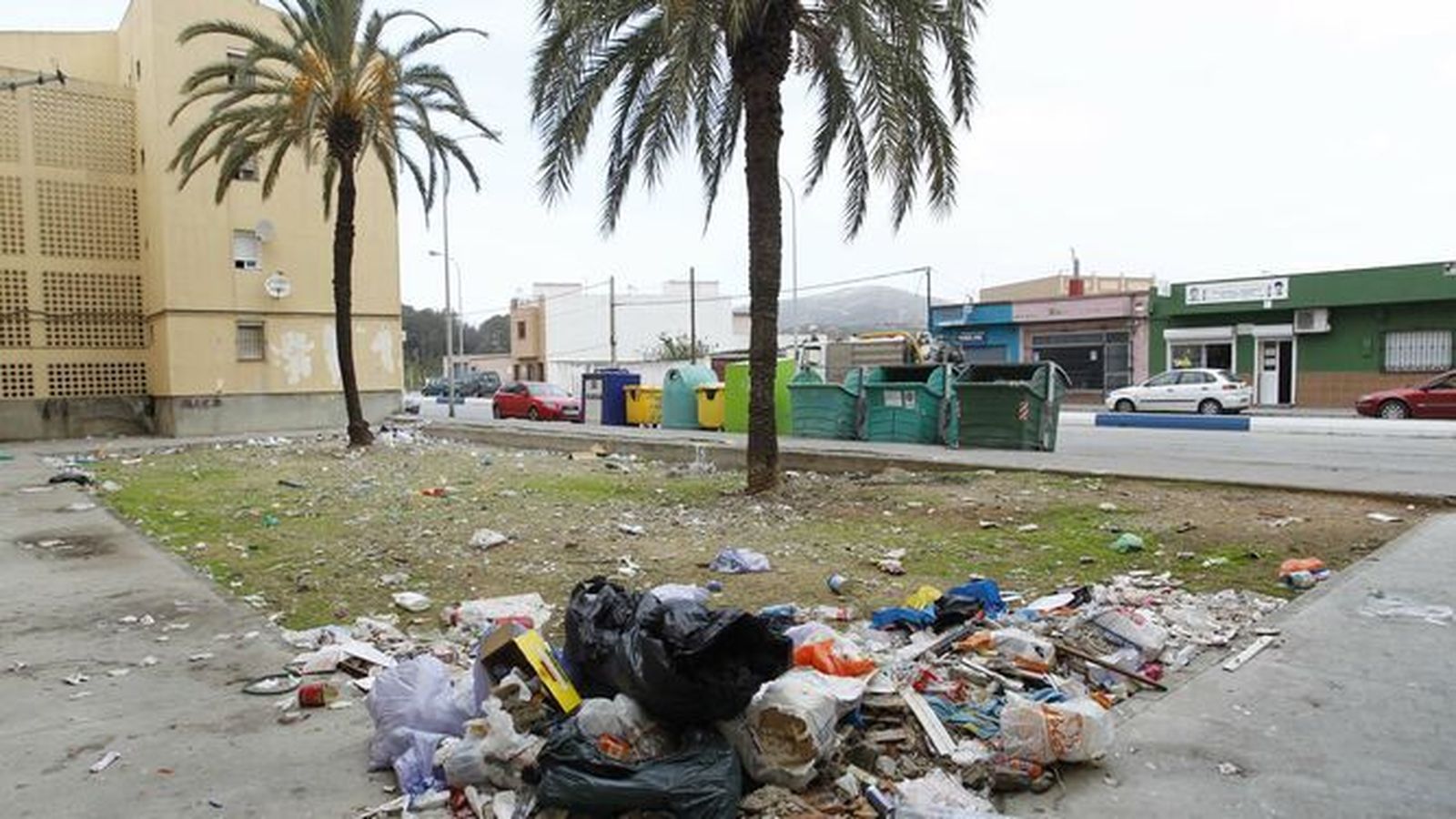 Basura esparcida cerca de contenedores de basura