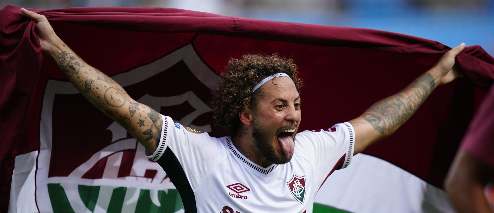 El lateral Guga celebra la clasificación del Fluminense con una bandera del club.