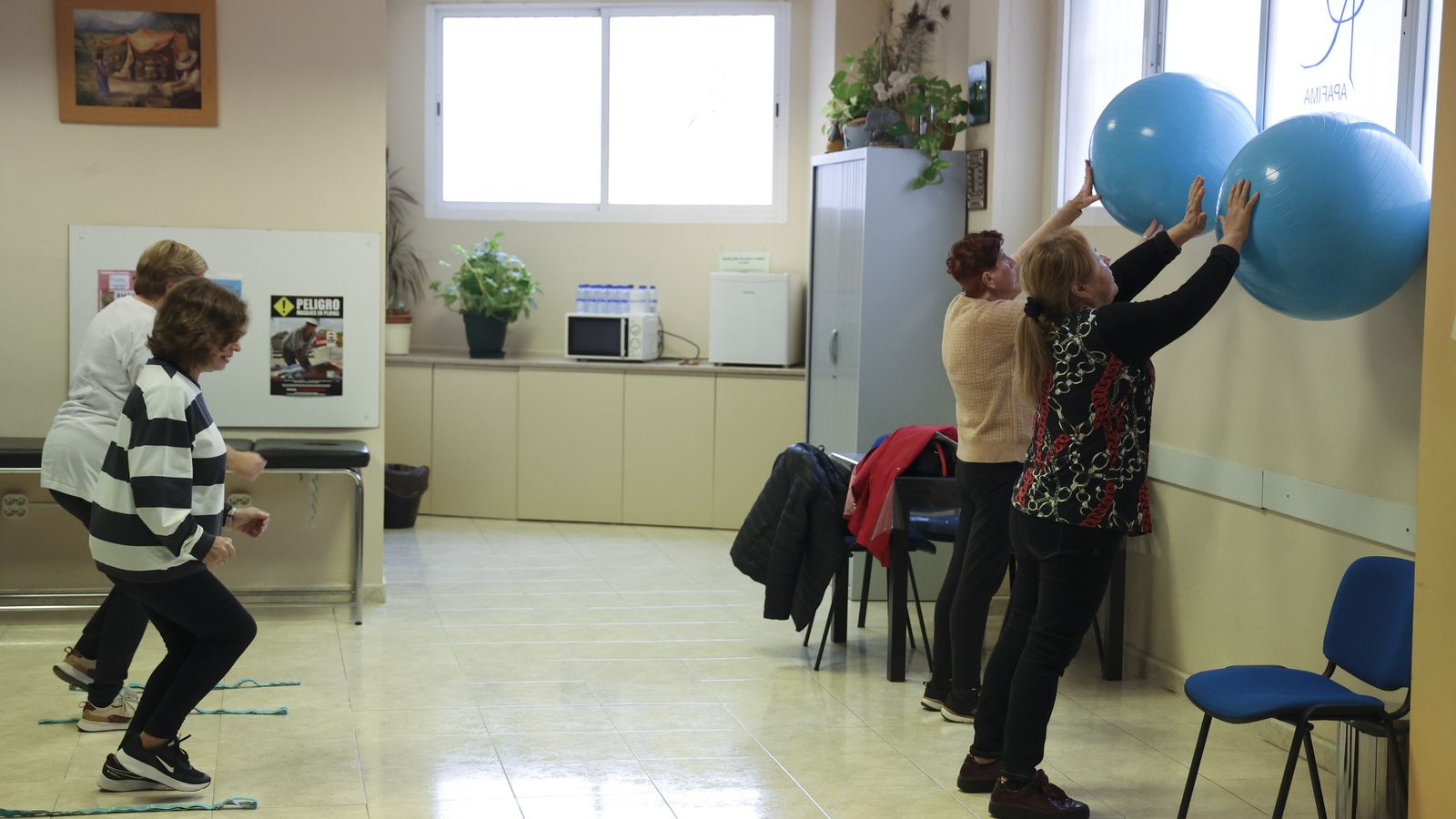 Las mujeres realizan ejercicio con pelotas en la sede de la asociación.