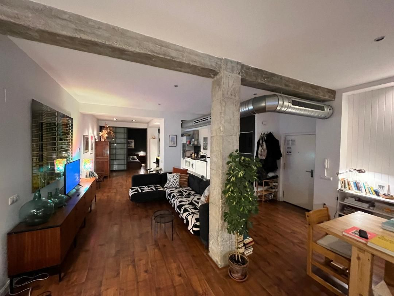 Vista general. El salón, la zona de trabajo, la cocina y el distribuidor se encuentran en un mismo espacio.