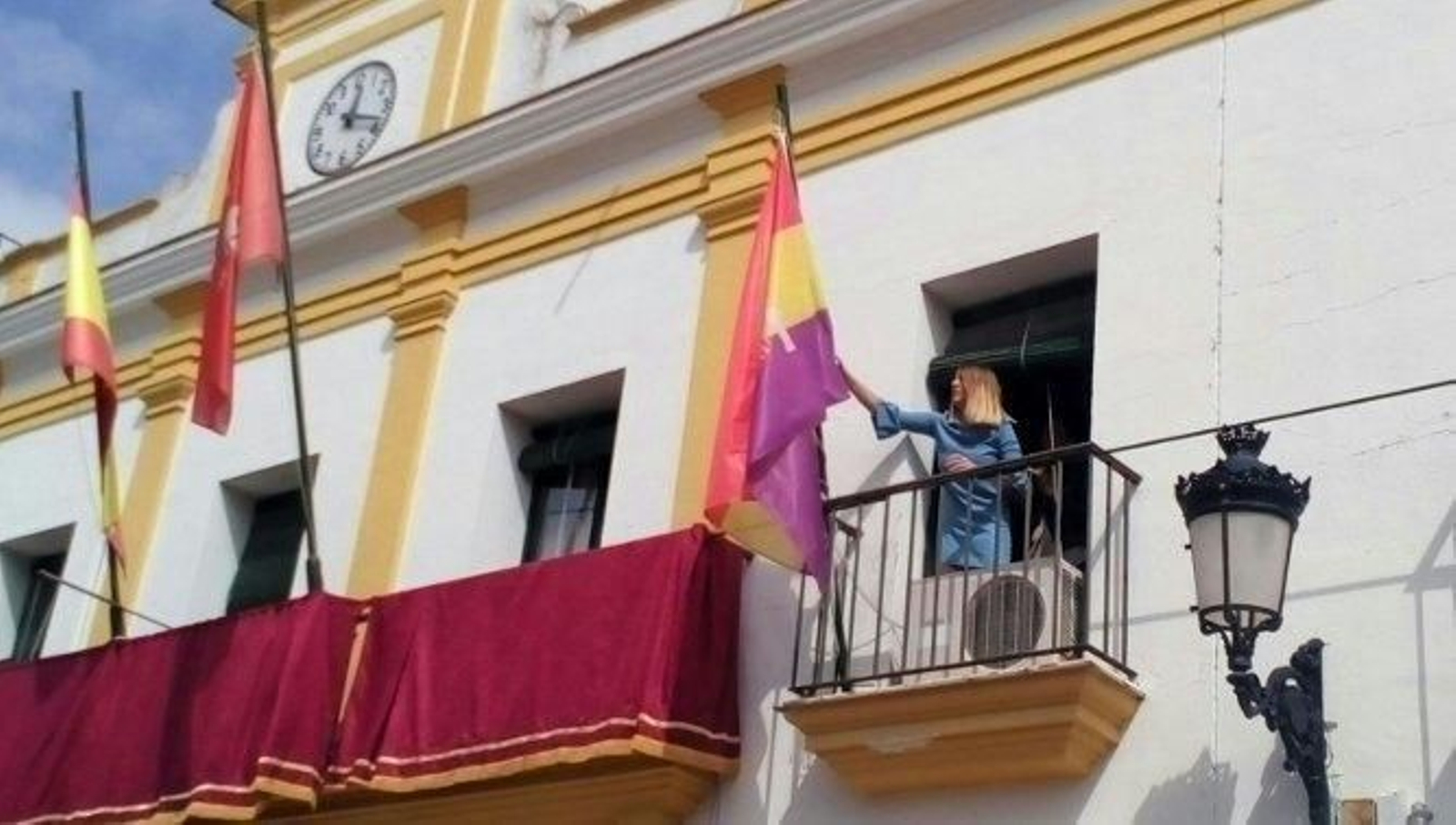 La primera teniente de alcalde de Trebujena, izando la bandera republicana el en Ayuntamiento.