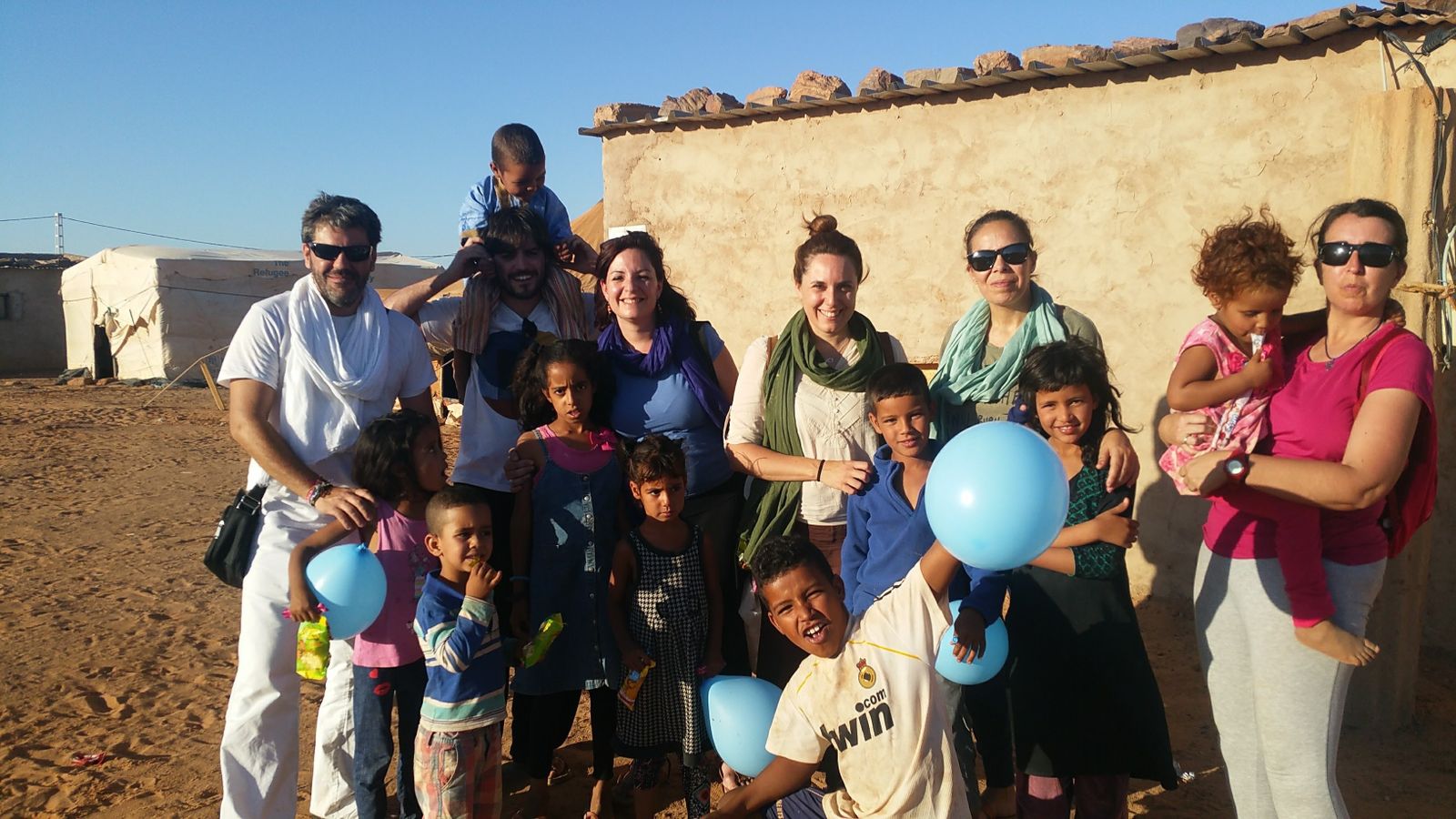 El concejal de Cooperación del Ayuntamiento de Carmona Juan Carlos Ramos (a la izquierda) junto a varios integrantes de la delegación y niños de Dajla.