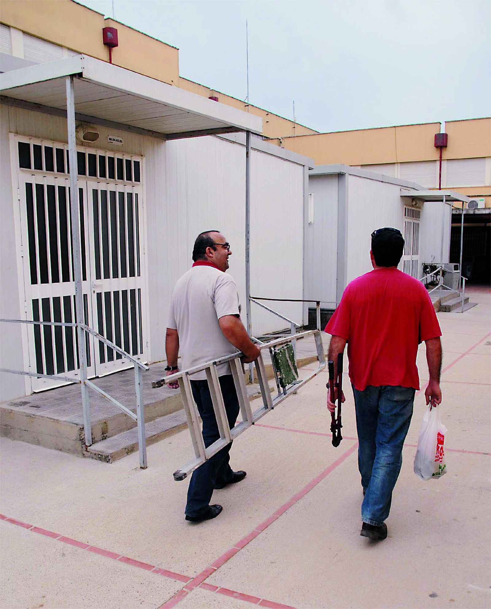 Dos trabajadores dedicados al mantenimiento de las aulas.