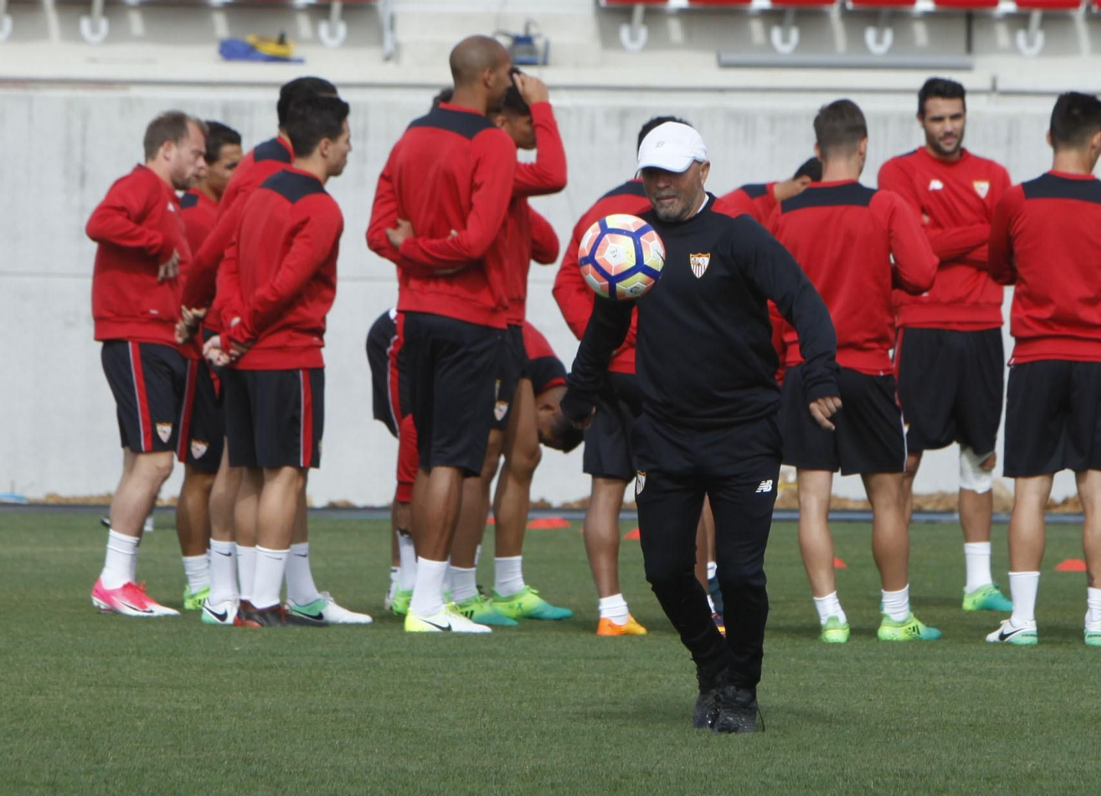 Jorge Sampaoli juguetea con el balón mientras sus jugadores escuchan las instrucciones de Jorge Desio.