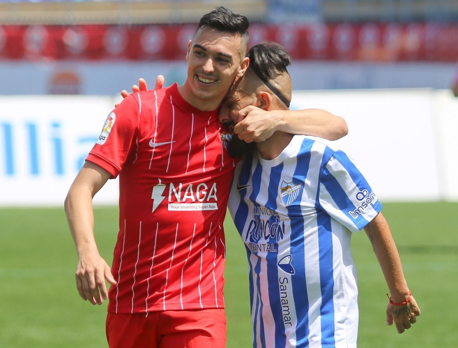 Abrazo entre el Málaga y el Sevilla.