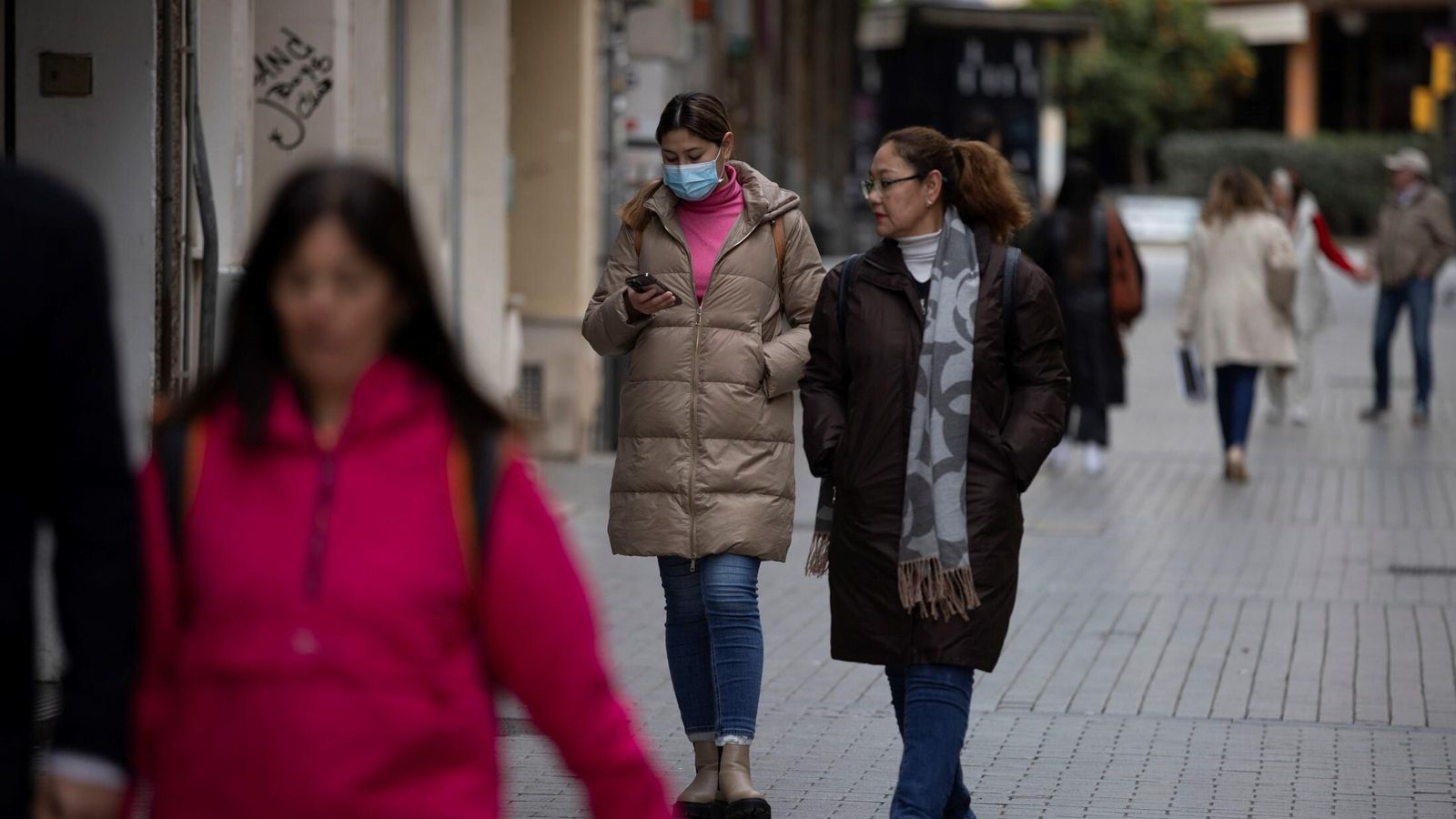 Una joven mira su móvil con una mascarilla, este lunes en Huelva. Una joven mira su móvil con una mascarilla, este lunes en Huelva.