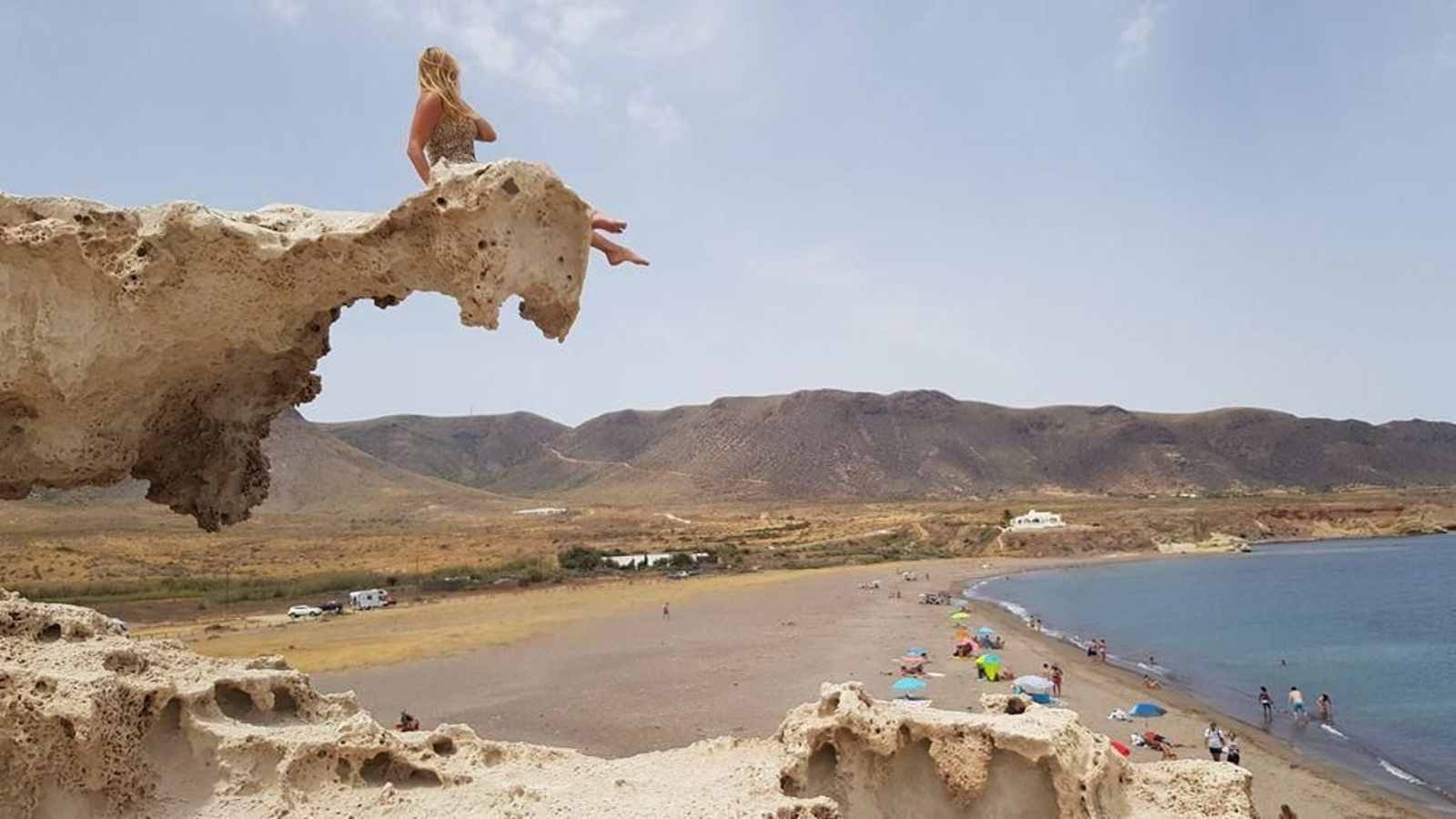 Una mujer se realiza una foto subida en la duna fósil de Los Escullos.
