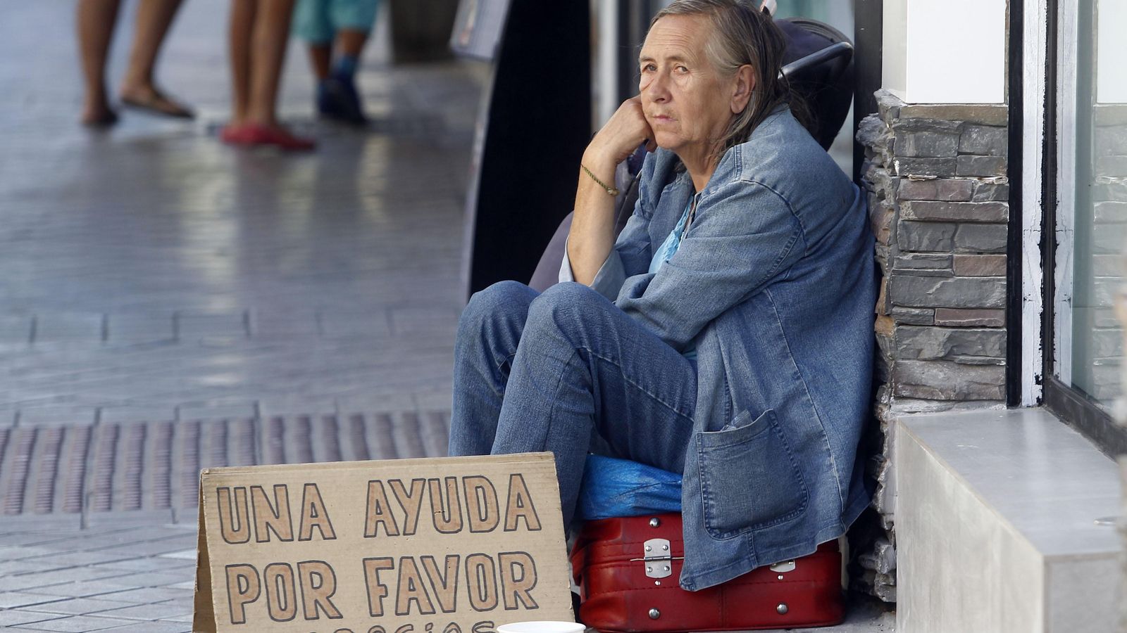 Una persona pide dinero en la calle.