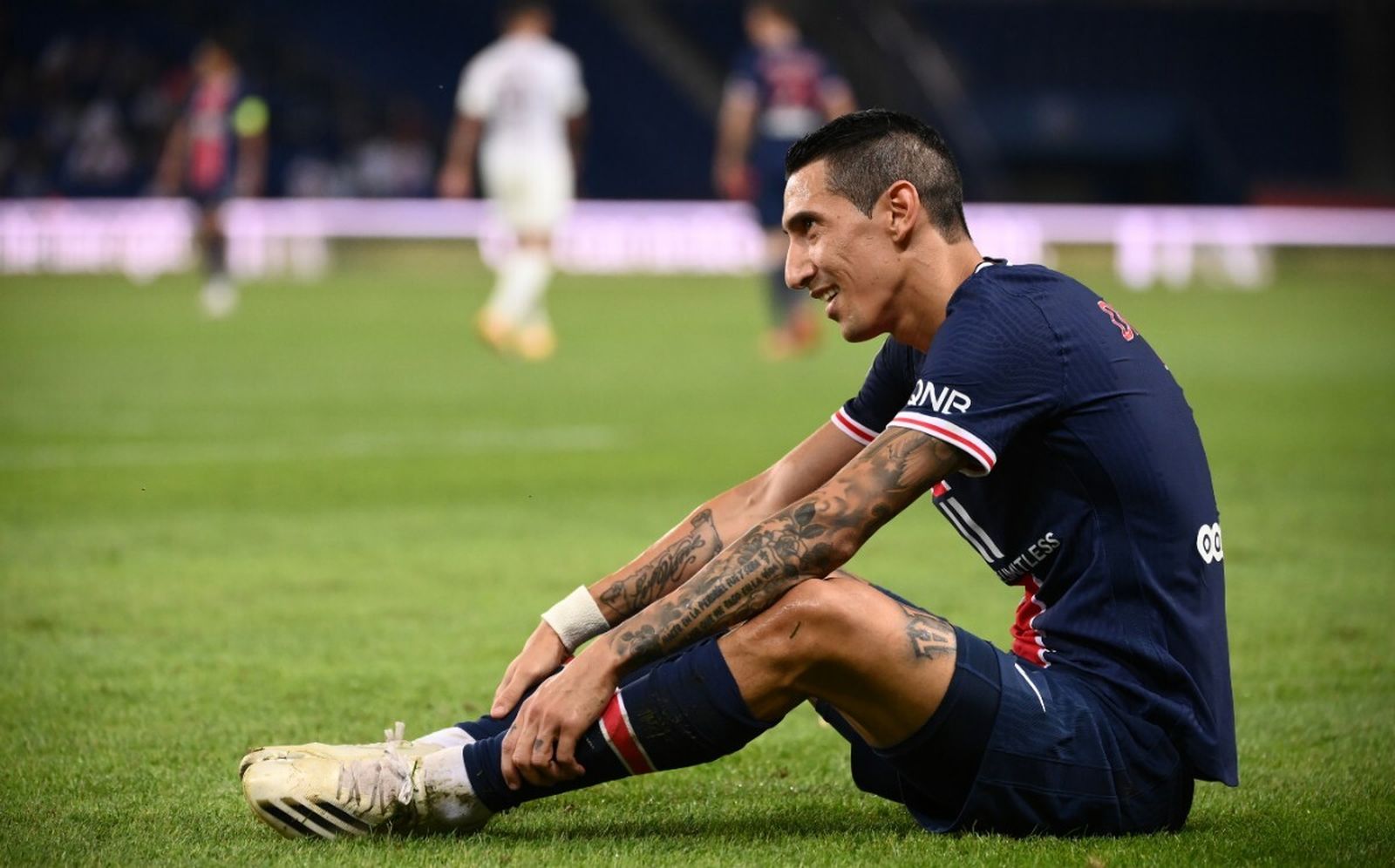 Di María sentado en el terreno de juego