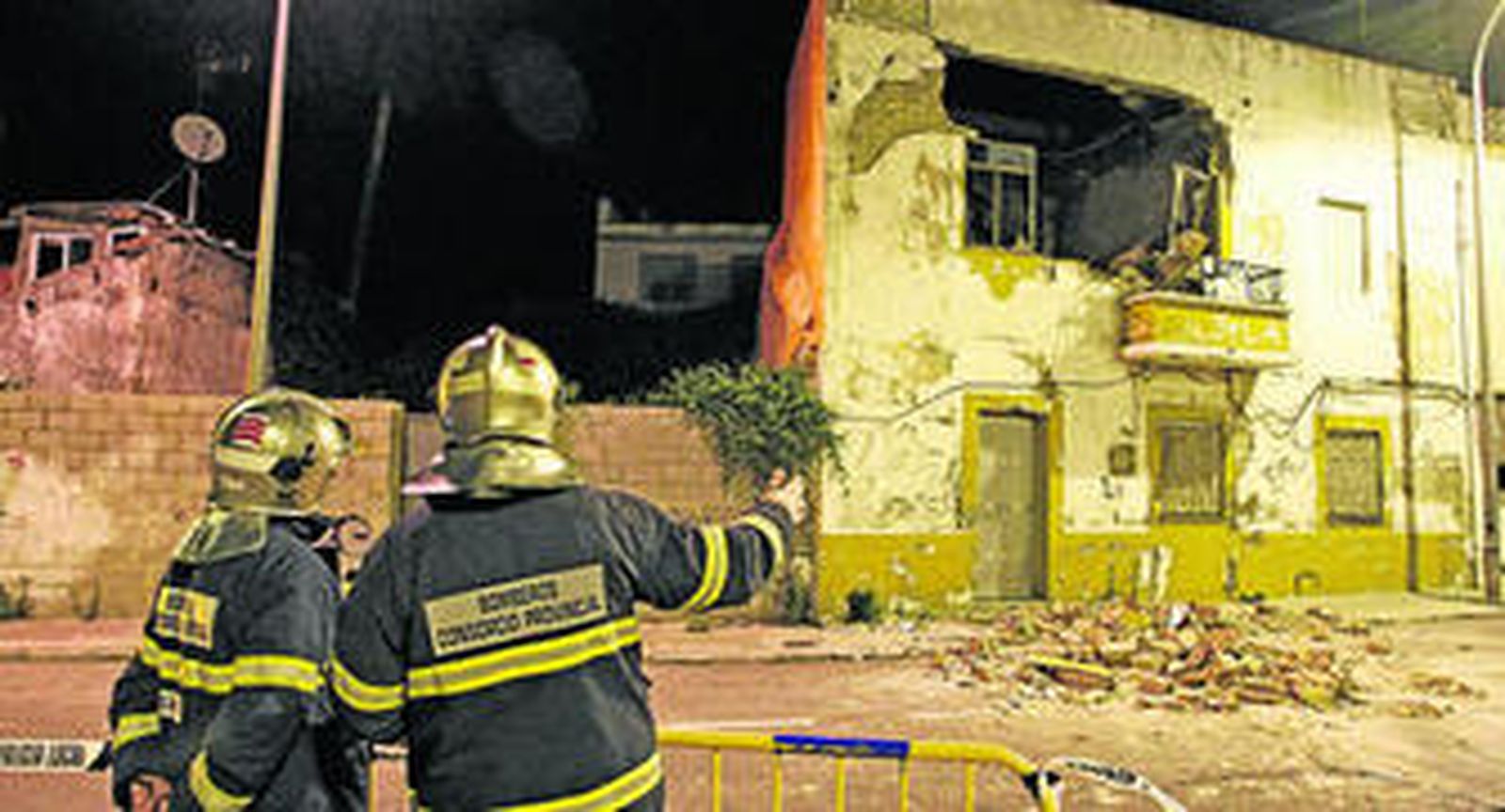 Dos bomberos observan el inmueble derruido parcialmente, anoche, en la Glorieta de Agustín Bálsamo.