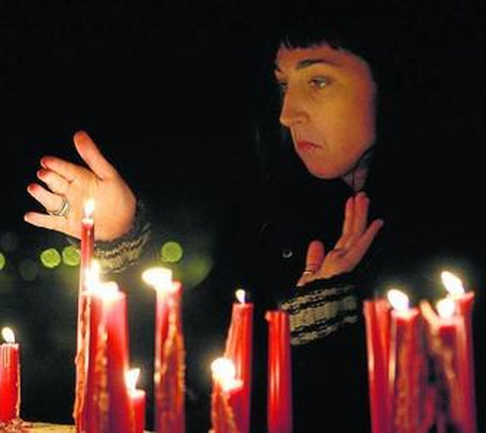 Una mujer enciende una vela durante una concentración en Sevilla contra la violencia de género.