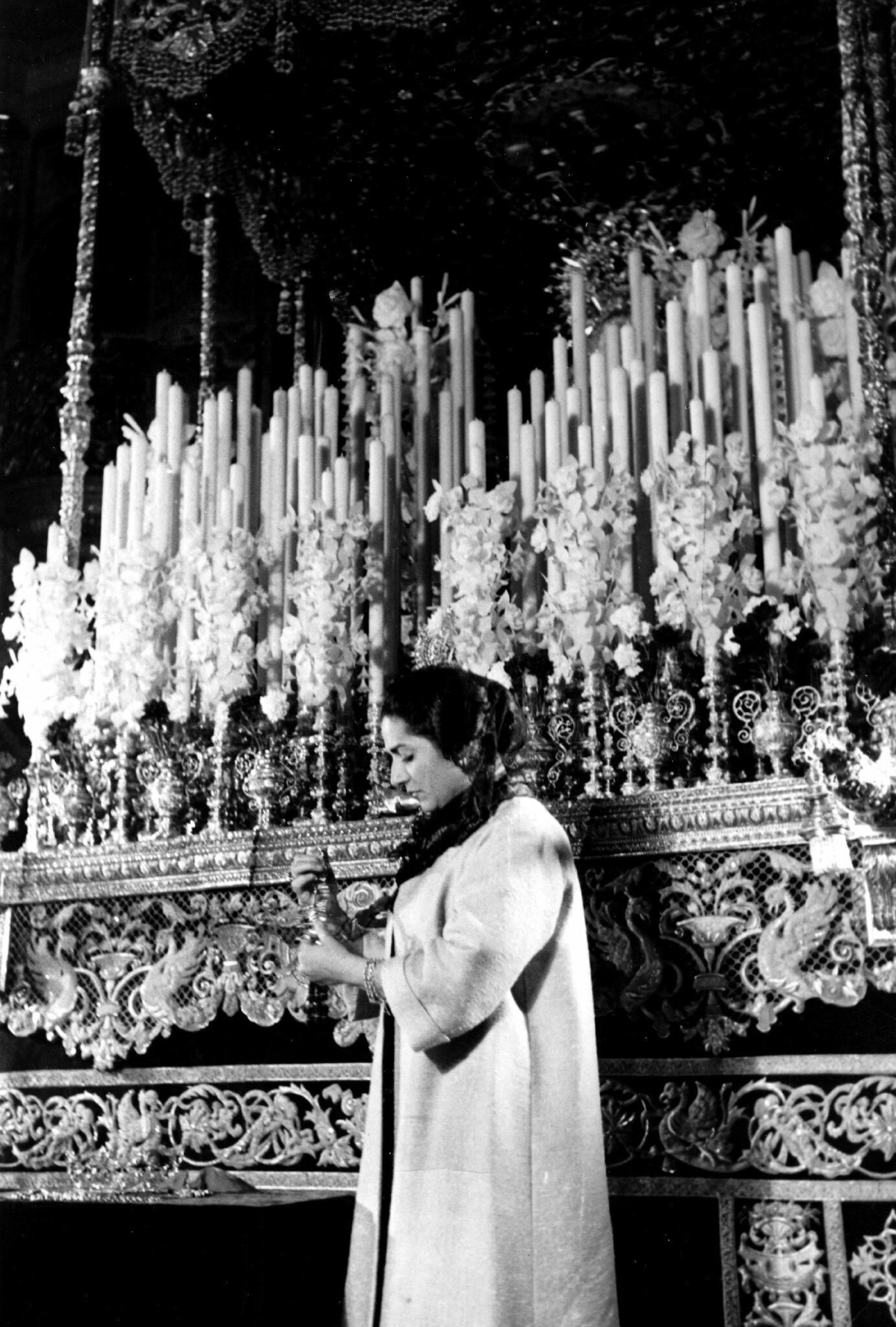 Juanita Reina agarrada a una manigueta del paso de la Virgen de la Esperanza.