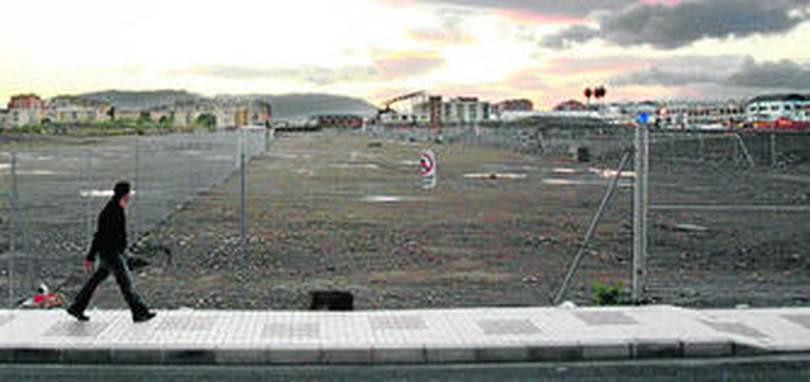 Un peatón camina por la Avenida Juan XXIII, desde la que se observan los terrenos ganados con el soterramiento de las vías del tren.