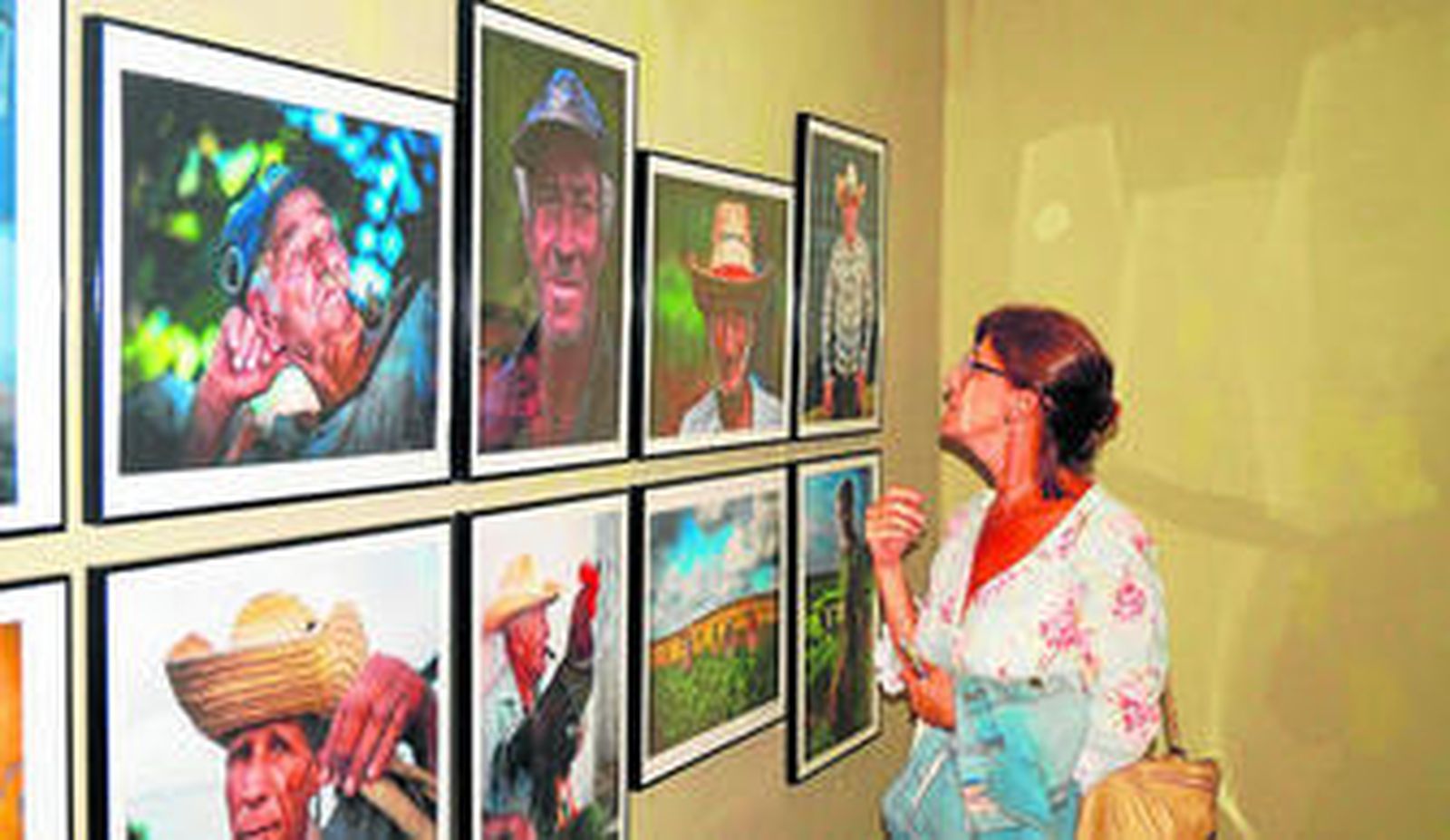Una mujer observa las fotografías de la exposición de Chip Cooper y Julio Larramendi.