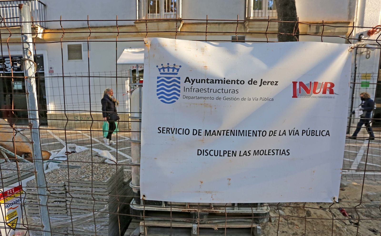 Cartel del Ayuntamiento en una de las vallas instaladas en Porvera para proteger el material de las obras.