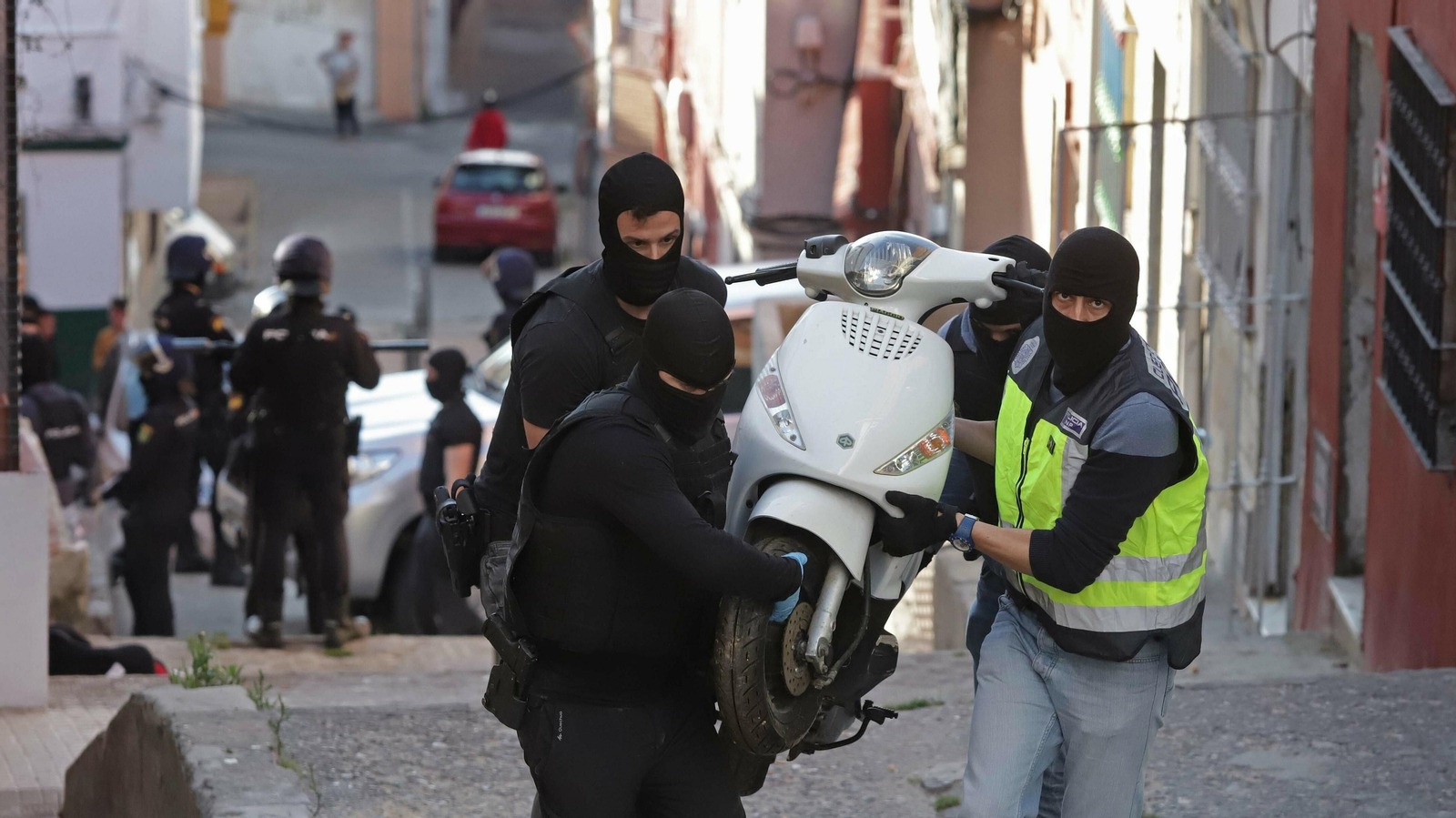 Agentes de la Guardia Civil transportan una moto incautada en La Bajadilla.