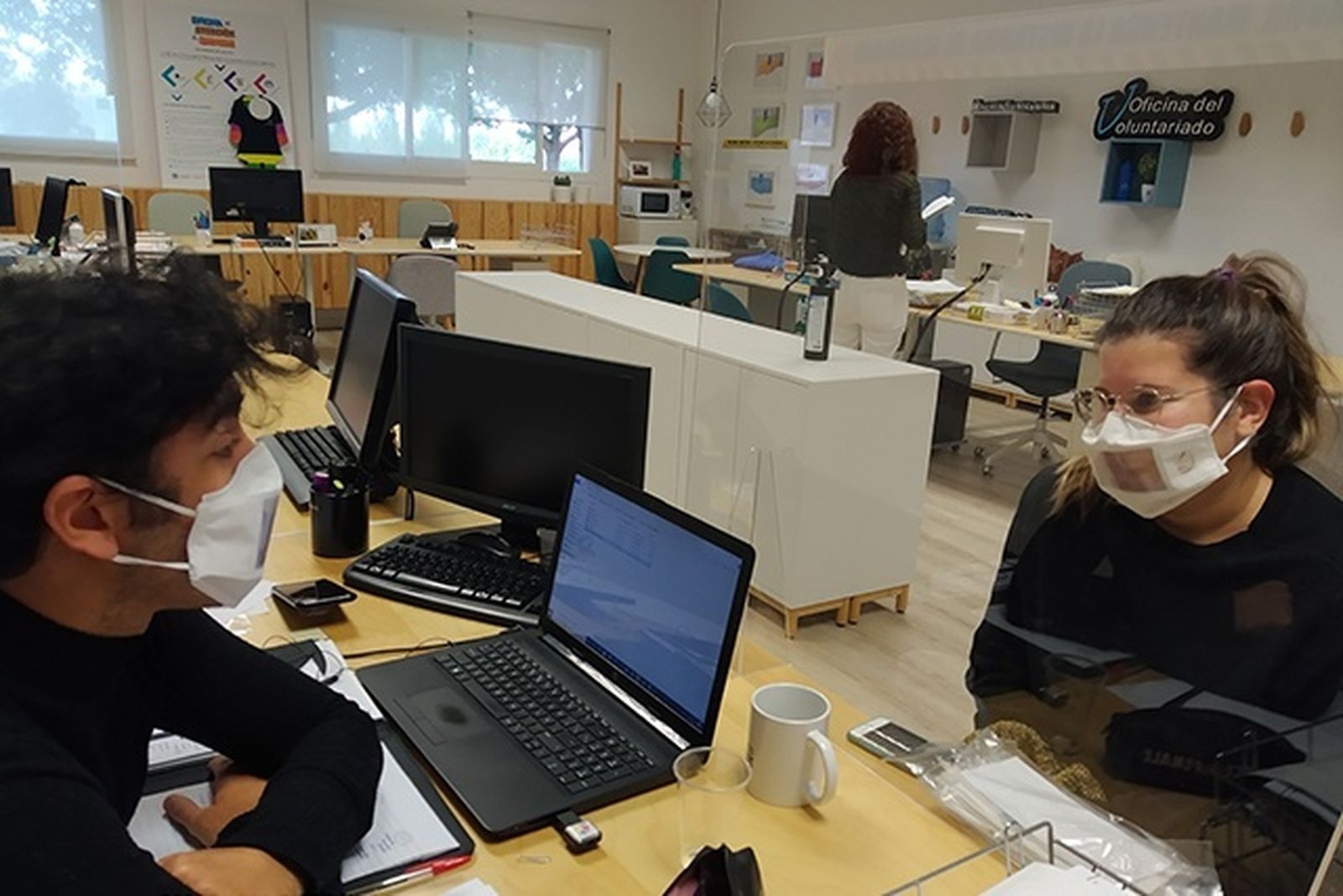 Dos personas usan las llamadas mascarillas comunicativas o "con ventana".