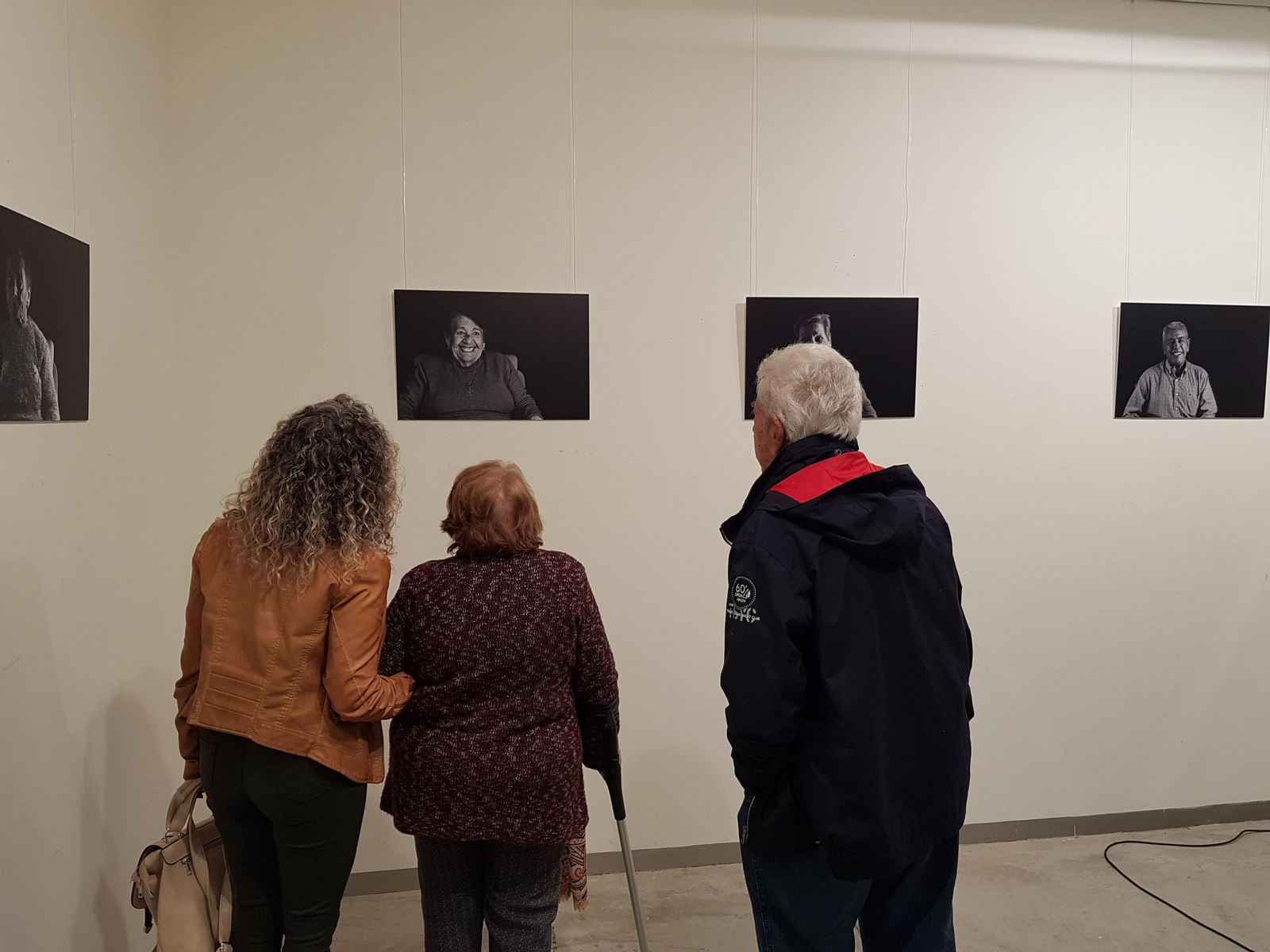 Una usuaria de Ángeles Teysa observa su propio retrato, en la muestra 'Años de felicidad'.