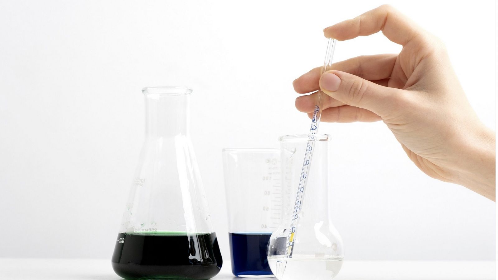 Una persona tomando una muestra de una probeta.