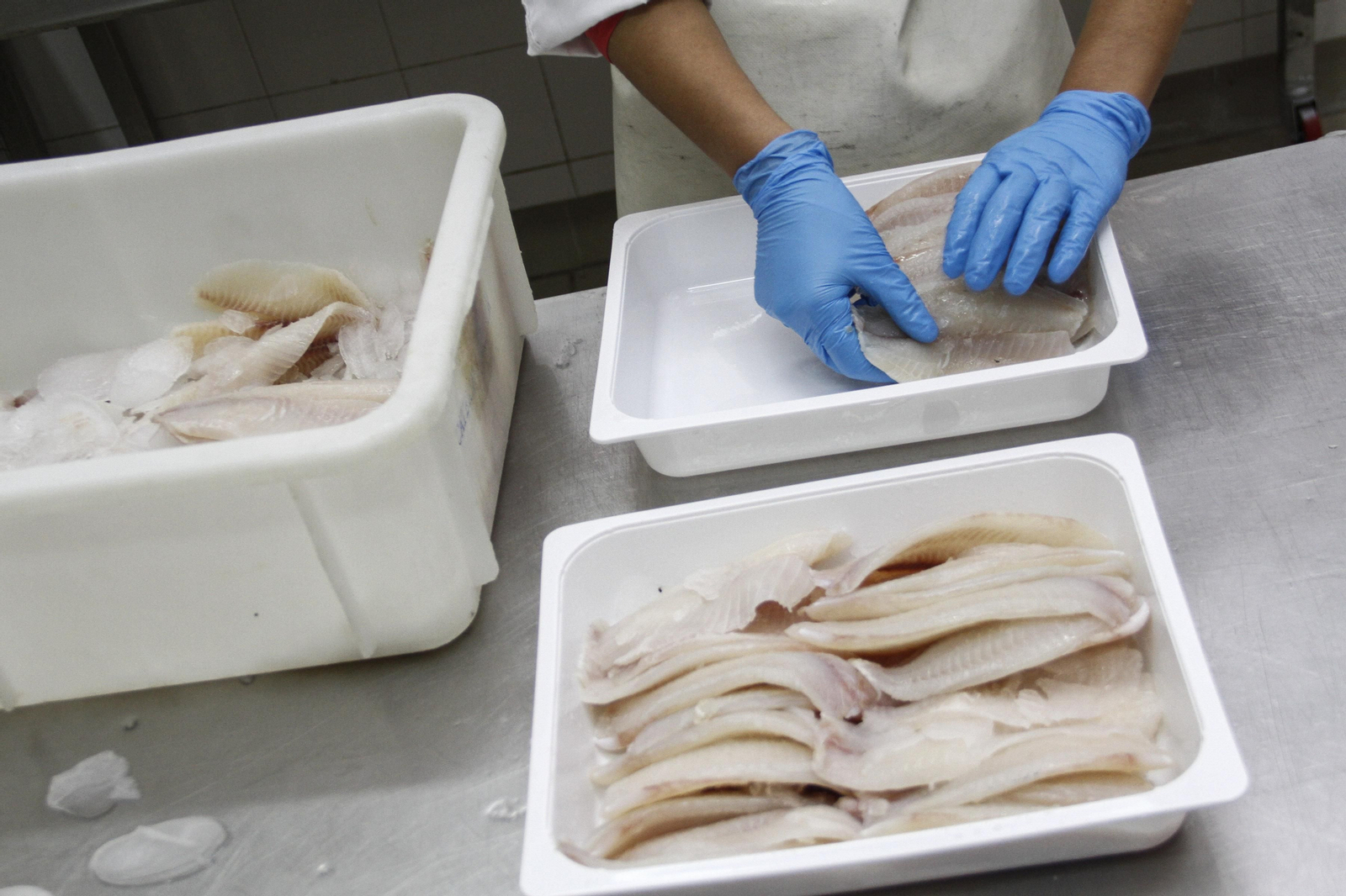 Preparación de pescado para un menú escolar en una empresa de cátering.
