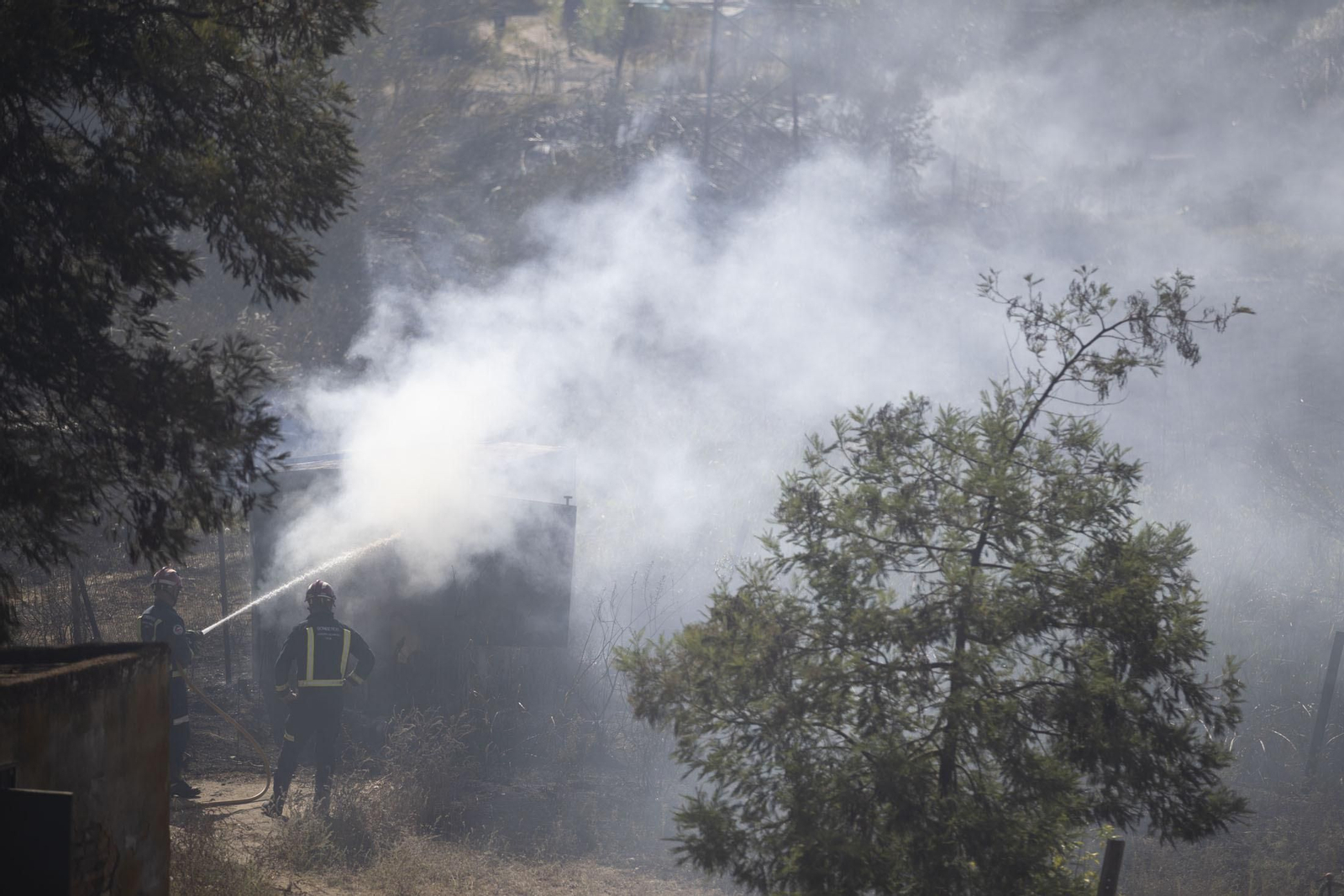 Dos efectivos del Consorcio Provincial de Bomberos en plena lucha contra las llamas.