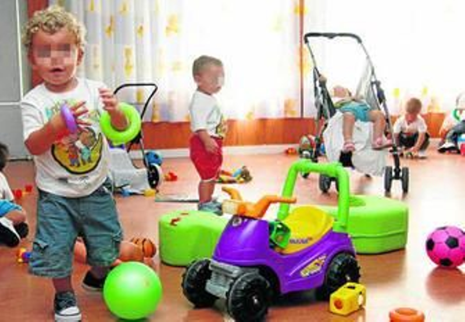 Varios niños juegan en el aula de una guardería sevillana de convenio.
