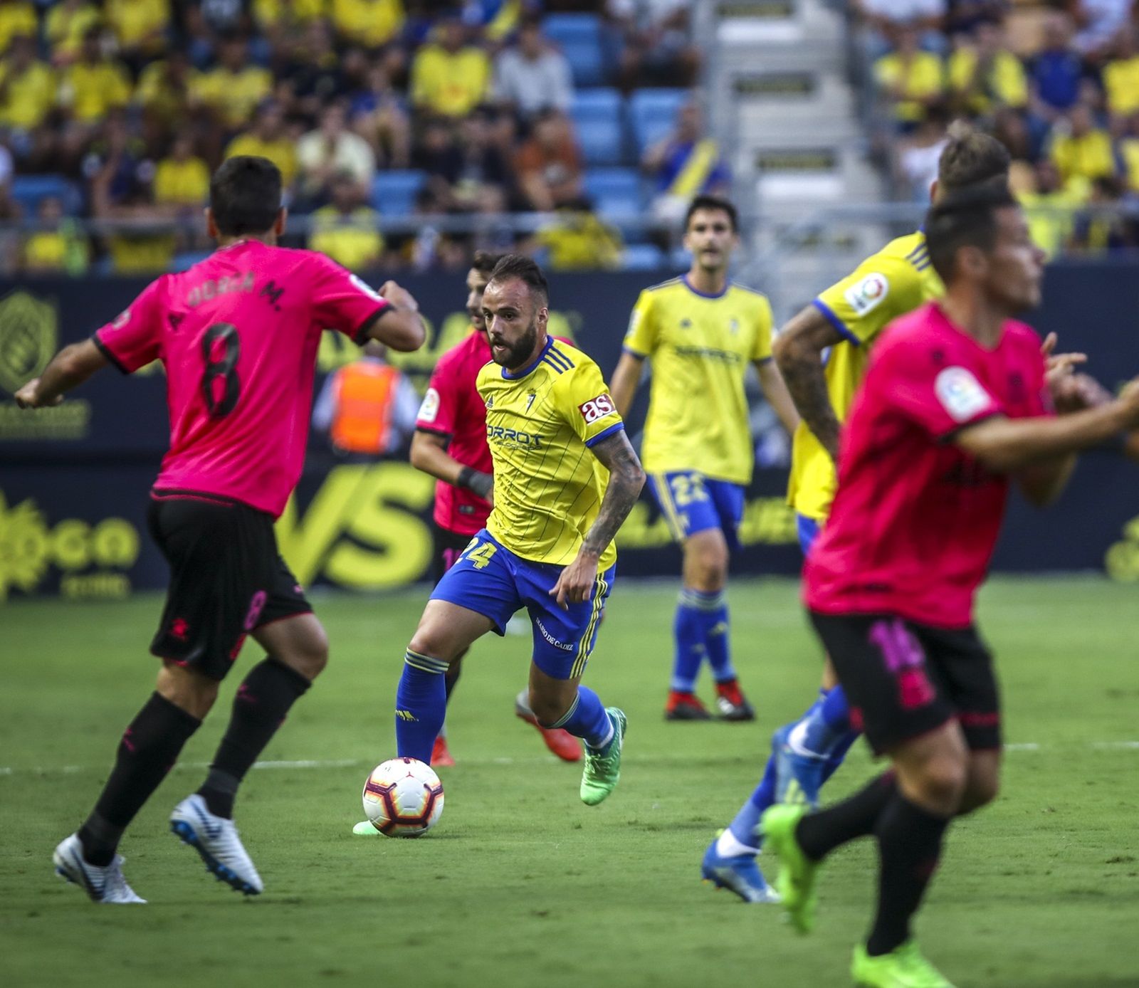 Edu Ramos controla el esférico rodeado de compañeros y rivales.