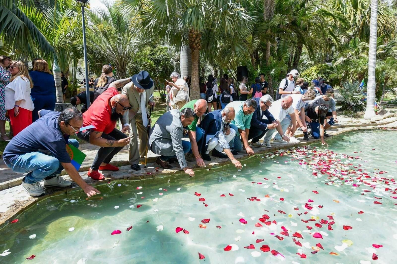 Varios hombres tirando pétalos de rosas en la tradicional ceremonia del río.