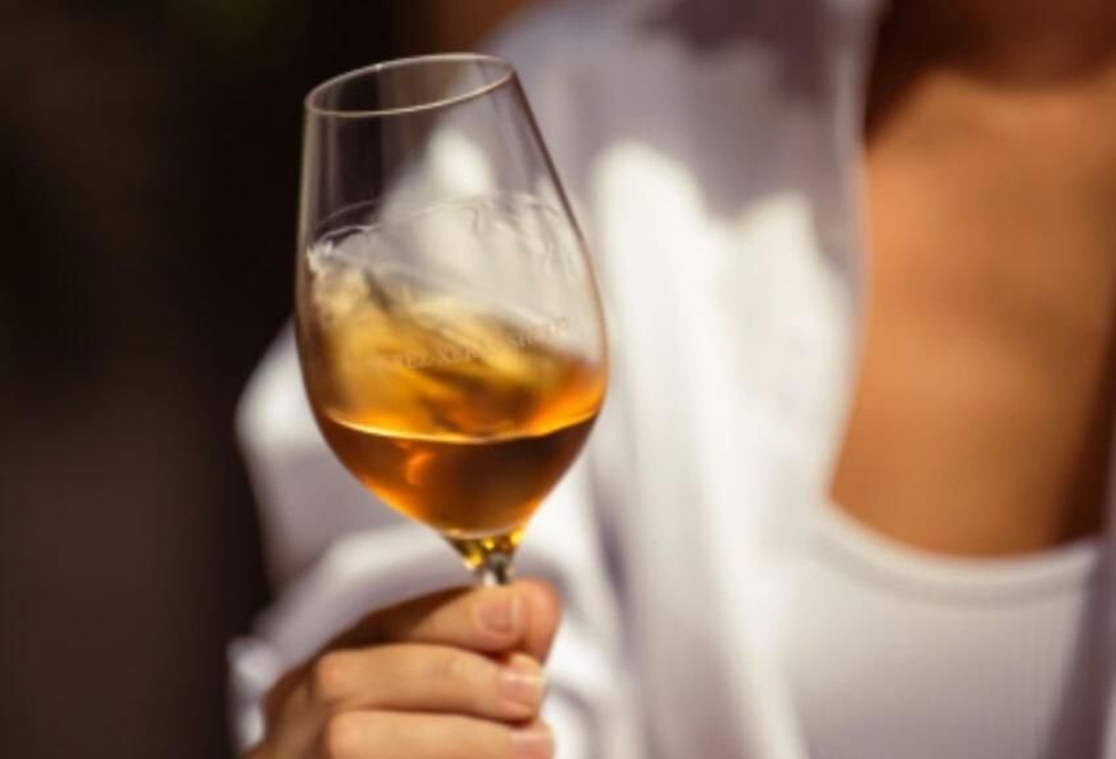 Una mujer disfruta de una copa de vino de Jerez al sol, una combinación fabulosa para la guía de viajes Lonely Planet