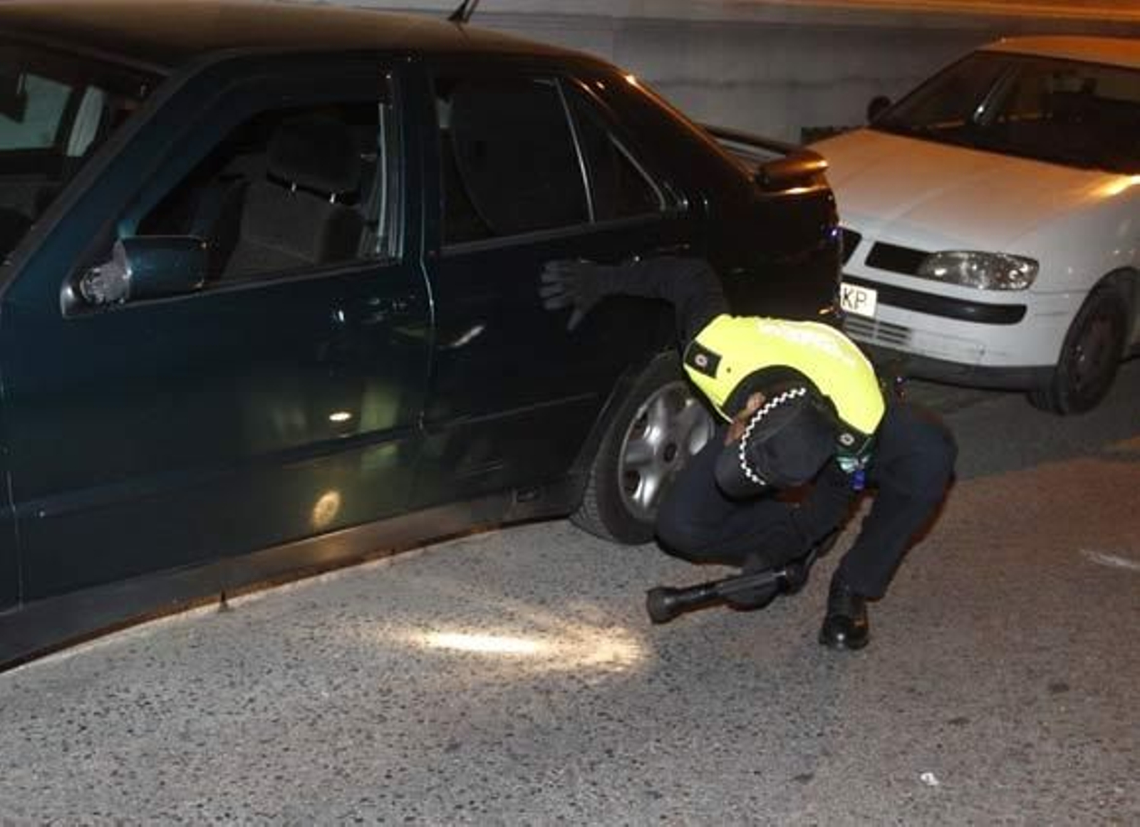 Un policía busca el arma del crimen bajo el coche.

Foto: Antonio Pizarro