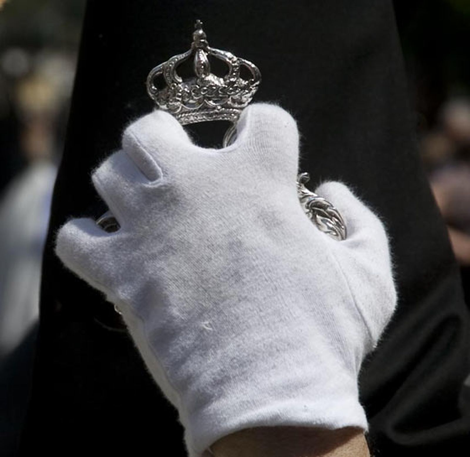 Detalle de la mano de un nazareno sujetando su vara en una de las paradas de la estación de penitencia.

Foto: Jaime Martínez