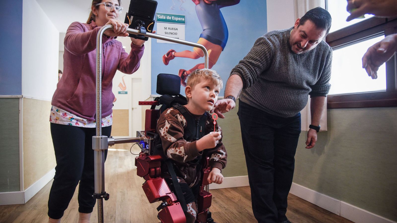 Pepe junto a su padre y las fisioterapeutas durante la terapia.