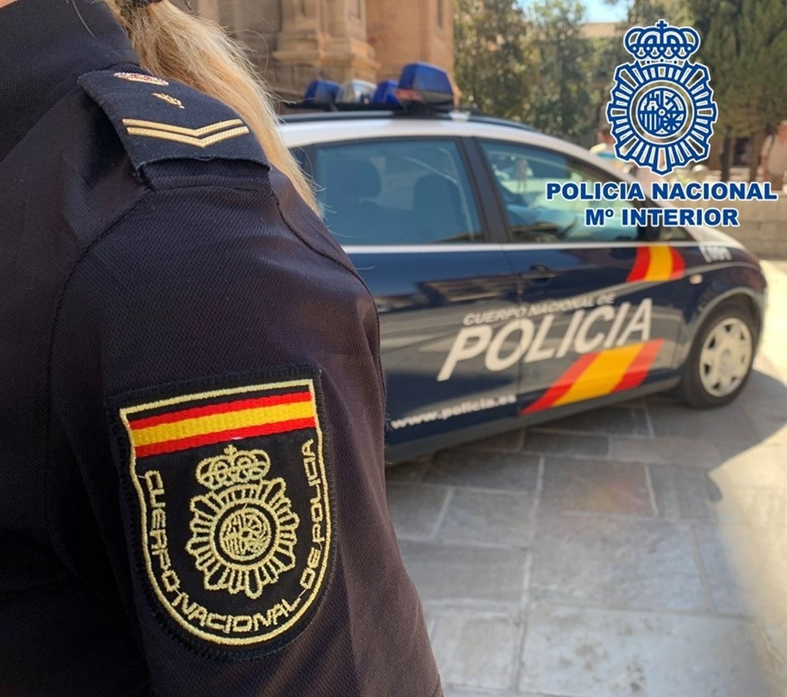 Imagen de archivo de un vehículo y una agente de la Policía Nacional de Granada