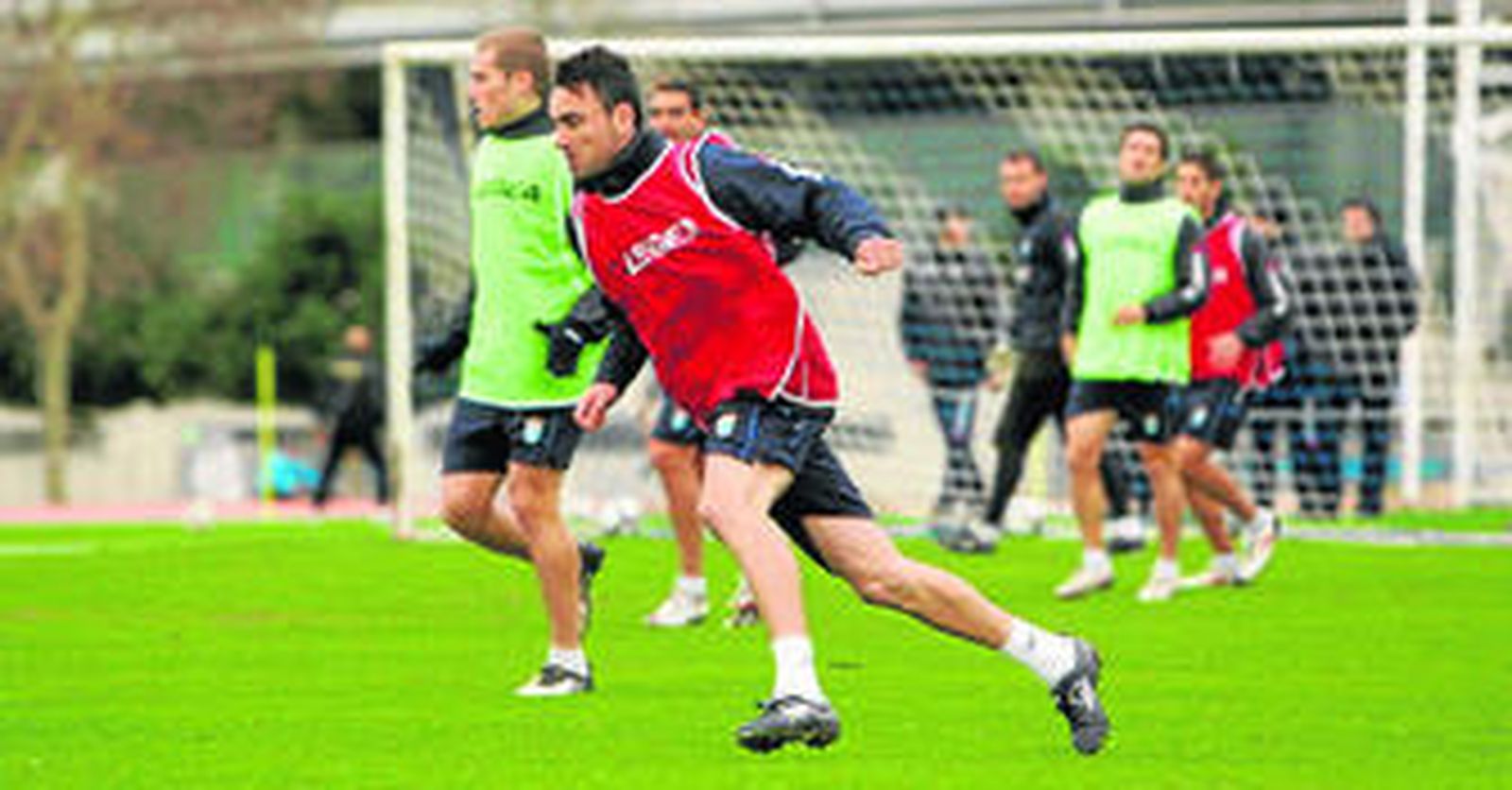 Momo se ejercita en un entrenamiento en el Anexo de Chapín, con Álex Bergantiños y otros jugadores al fondo de la imagen.