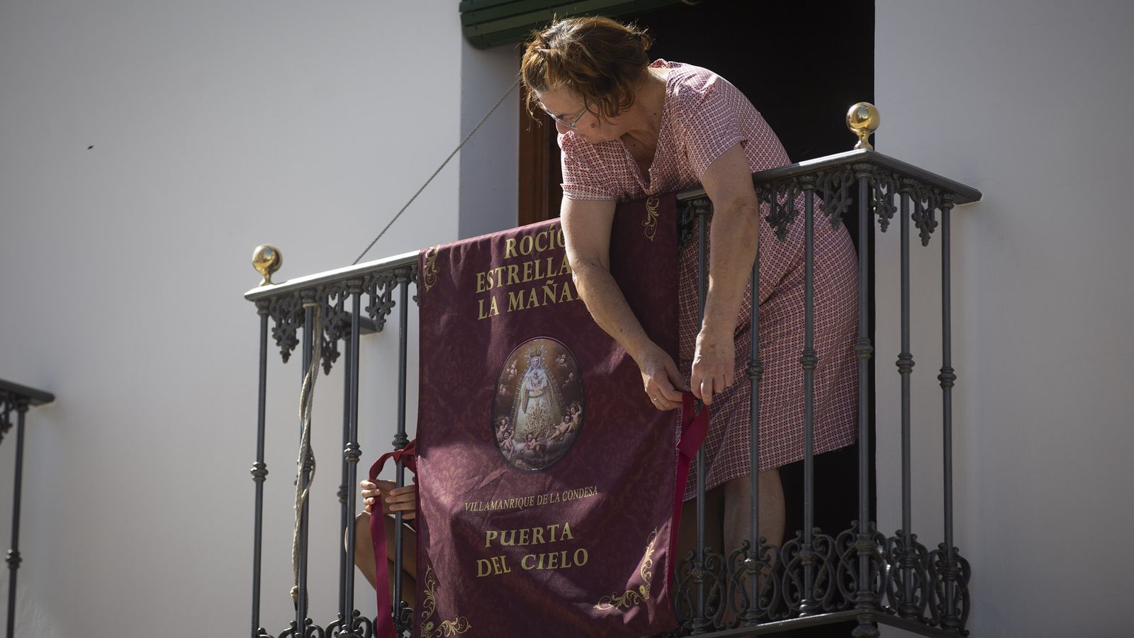 Una manriqueña coloca una balconera en honor a la Virgen del Rocío.