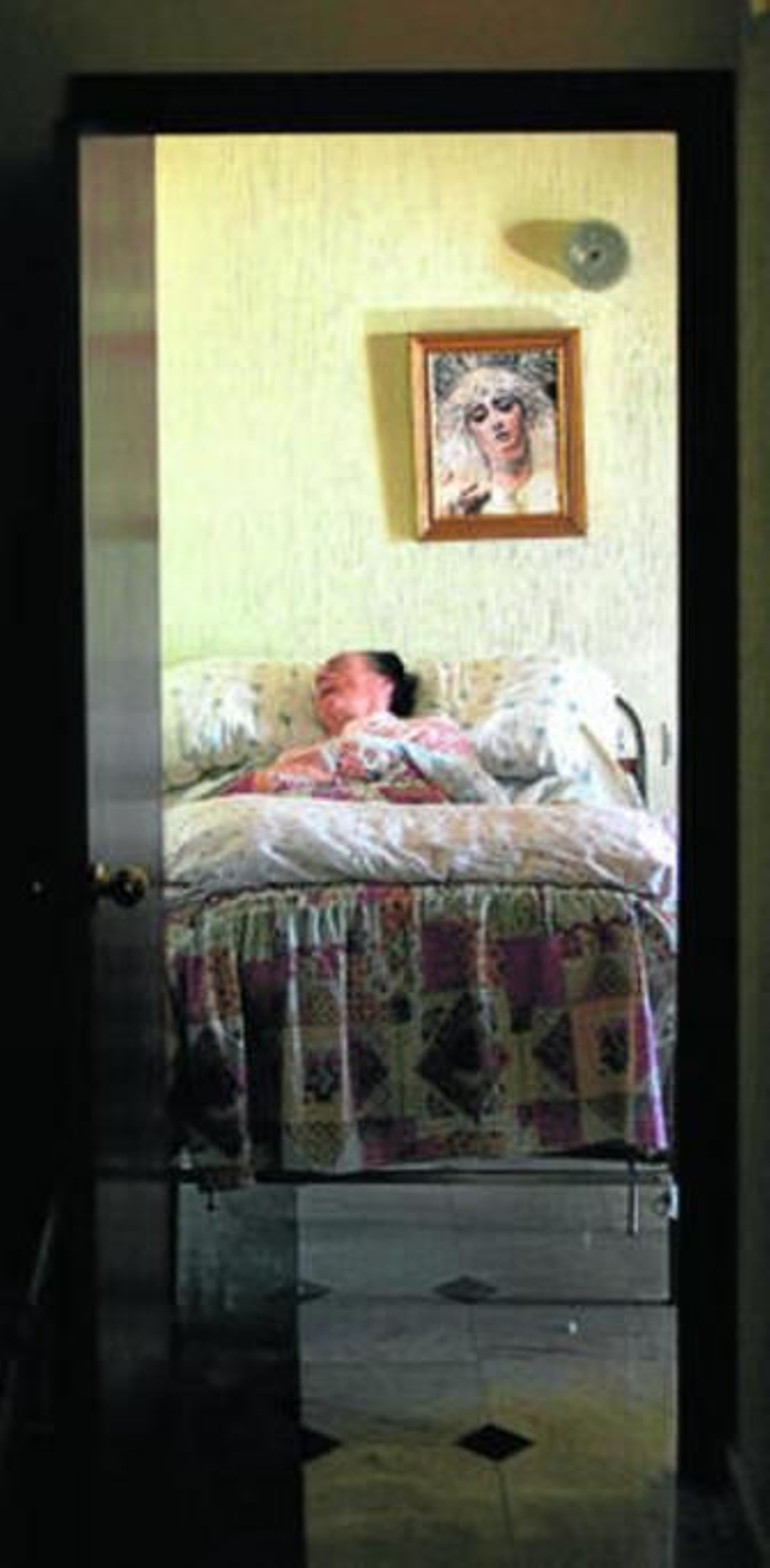 Una anciana, en un camastro.