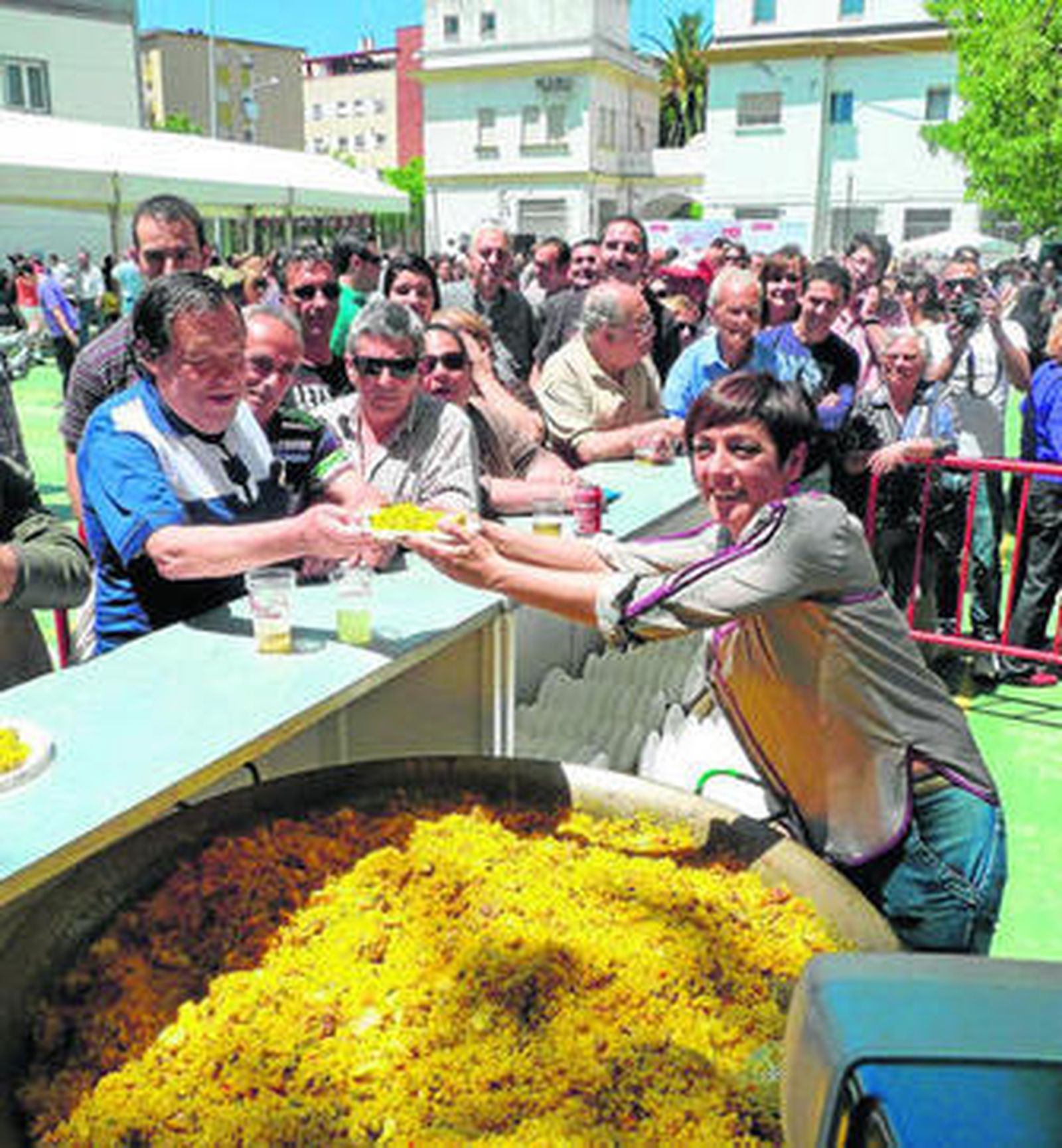 la candidata Marta Meléndez repartiendo la paella entre los asistentes a la fiesta.