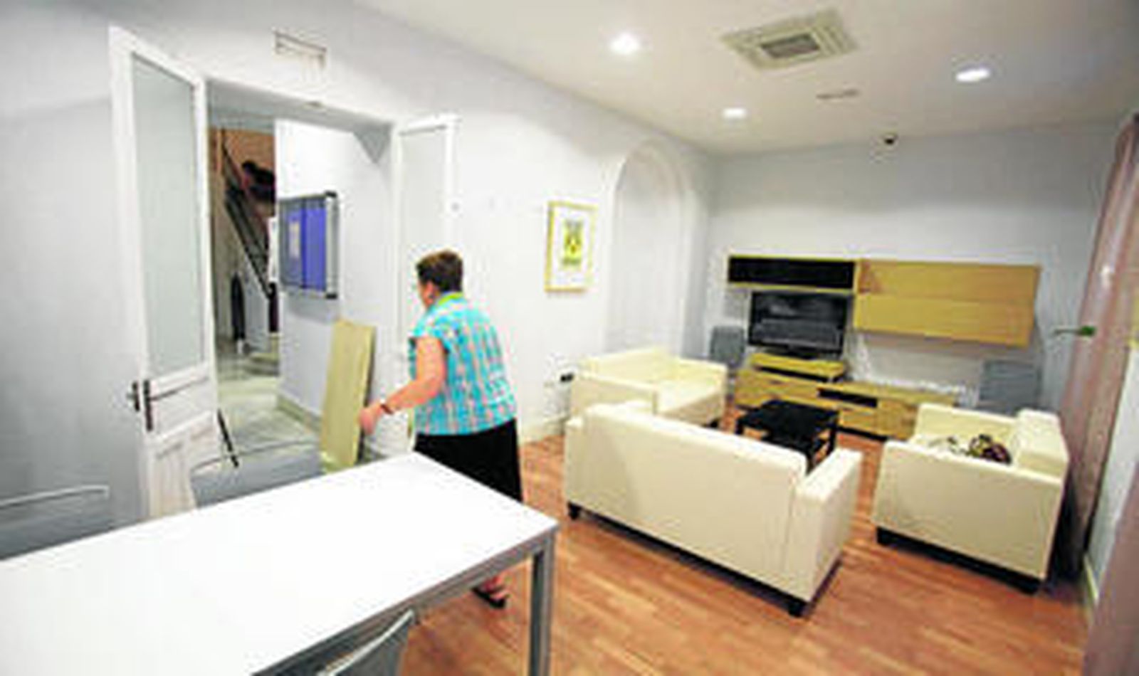 El salón comedor y la sala de televisión, situados en la planta baja del edificio y con un grabado de Cándida Garbarino en la pared.