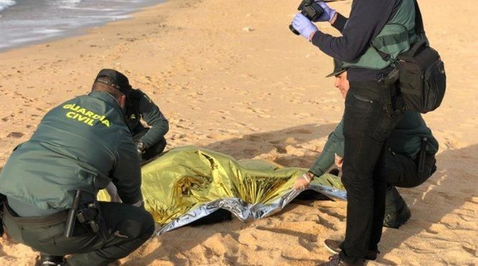 Los agentes tapan el cadáver de otro joven marroquí.