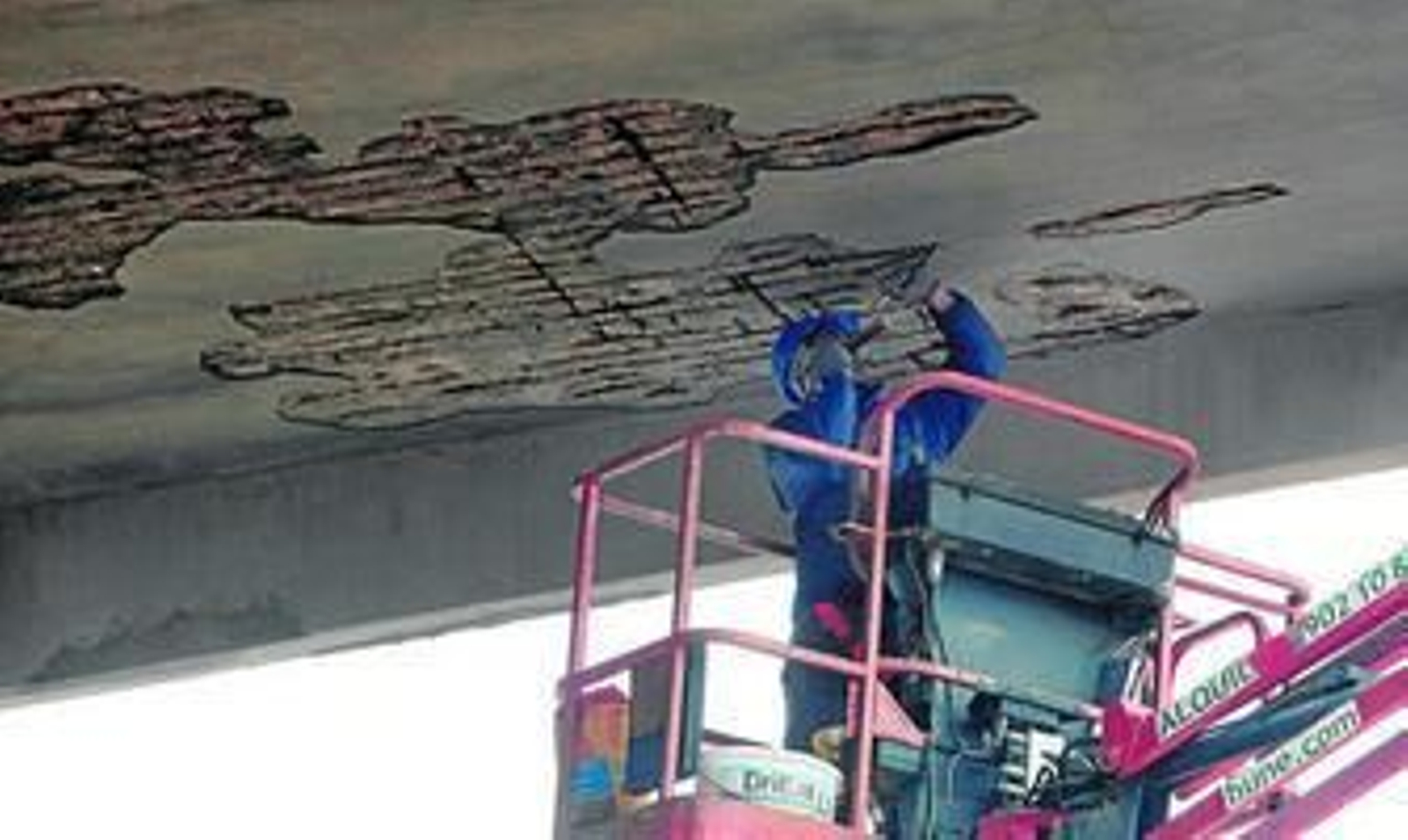 Un operario retoca la cara interna de la visera de la grada de tribuna, ayer en el Municipal.