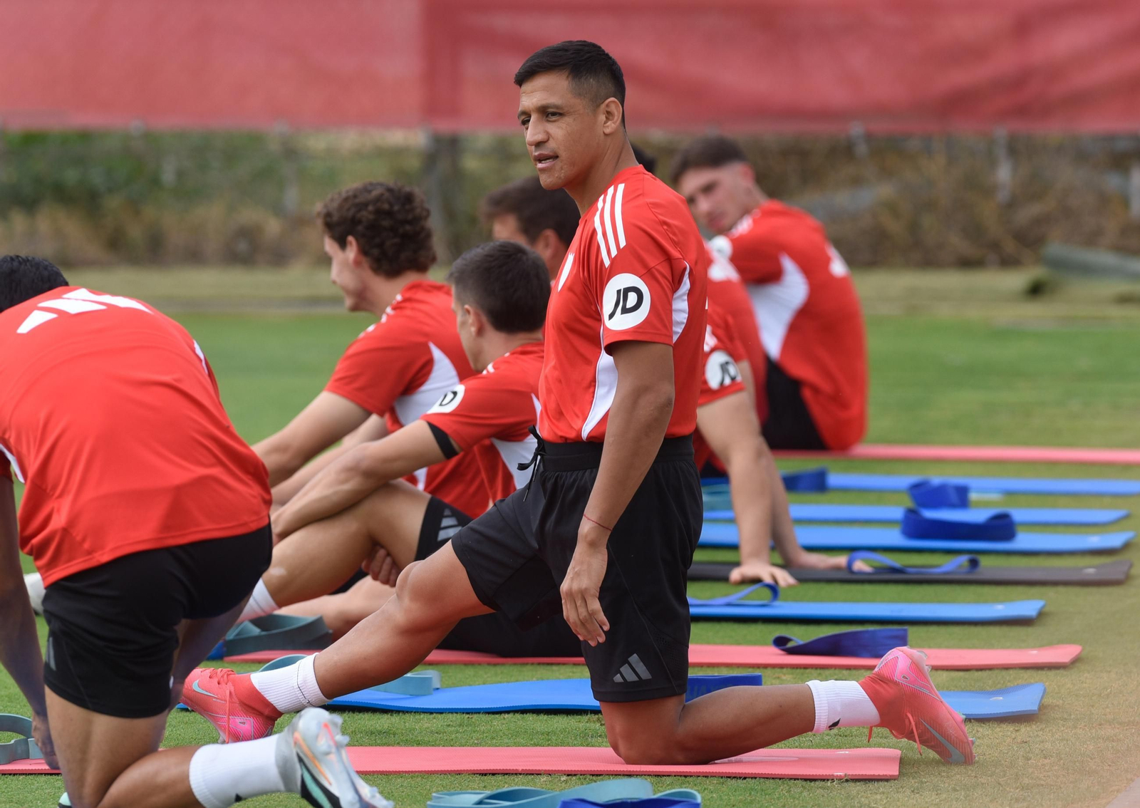 Alexis Sánchez estira en medio de un entrenamiento grupal.